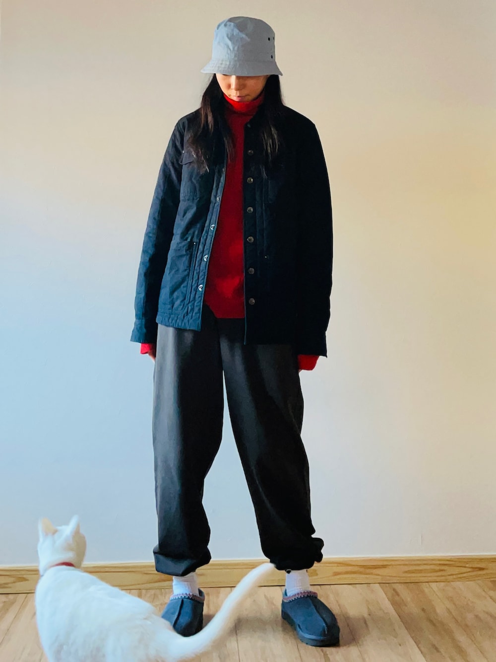 レッド系のニット/セーター、ブラック系のジャケット/アウター、グレー系のシューズを着用したレディースの冬コーディネートの2枚目の写真