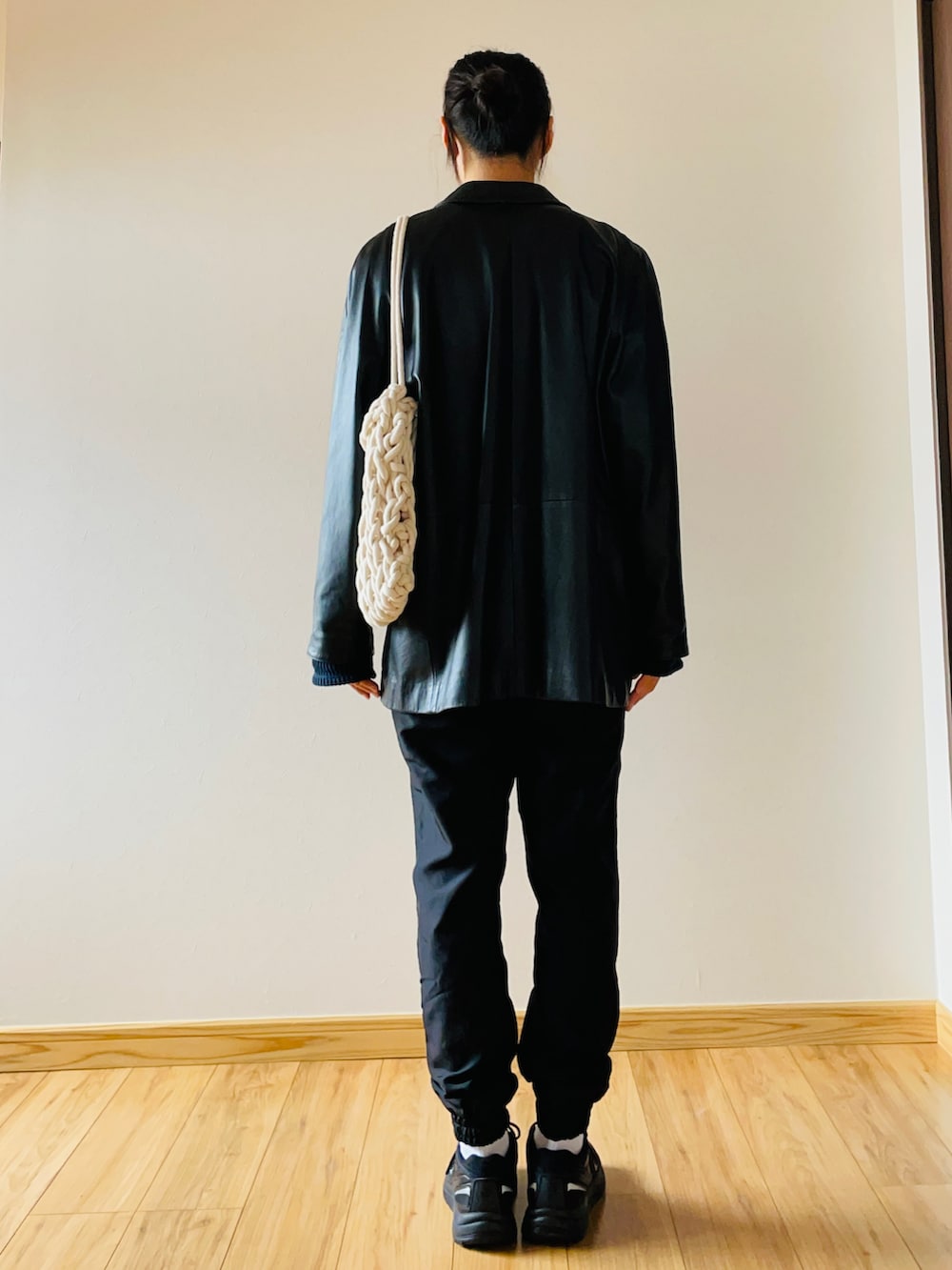 ブルー系のトップス、ブラック系のパンツ、ホワイト系のトートバッグを着用したレディースの冬コーディネートの2枚目の写真