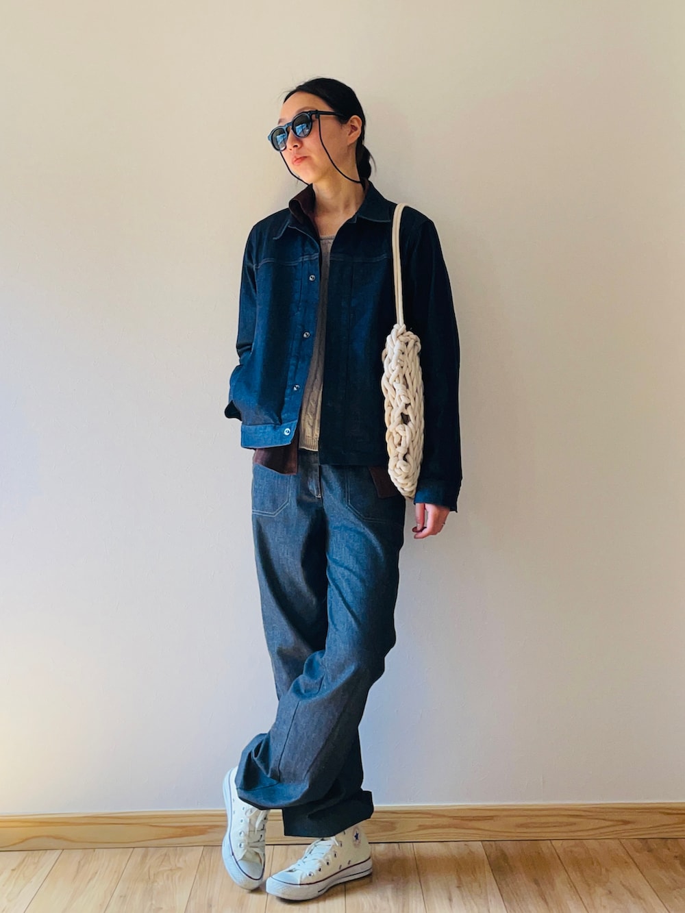 ブルー系のデニムジャケット、グレー系のニット/セーター、ブルー系のスラックスを着用したレディースの春コーディネートの2枚目の写真