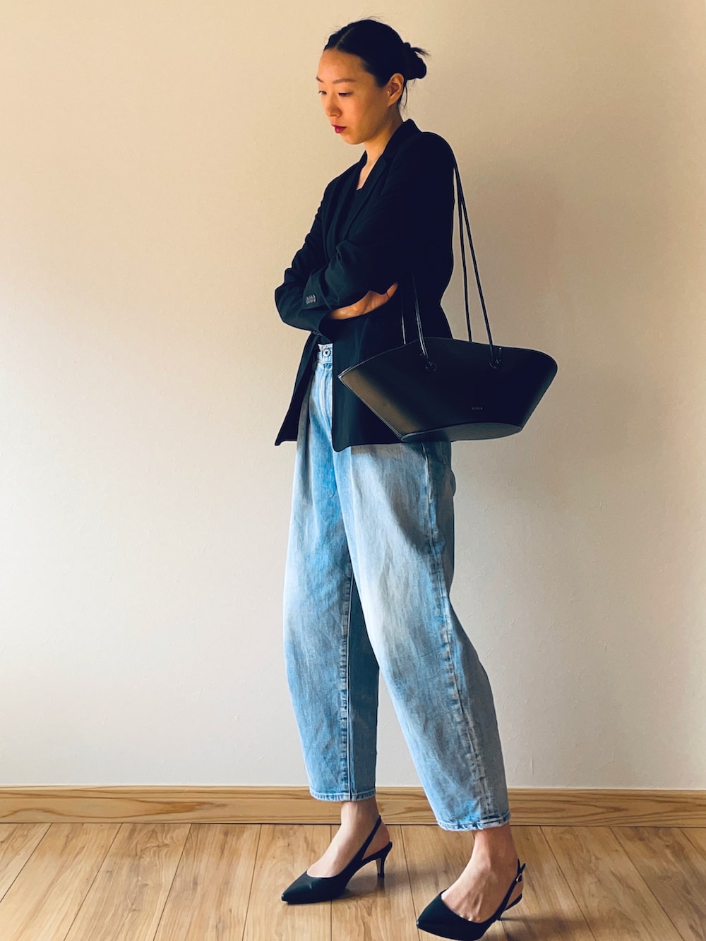 ブルー系のデニムパンツ、ブラック系のショルダーバッグ、ブラック系のキャミソールを着用したレディースの春コーディネートの3枚目の写真