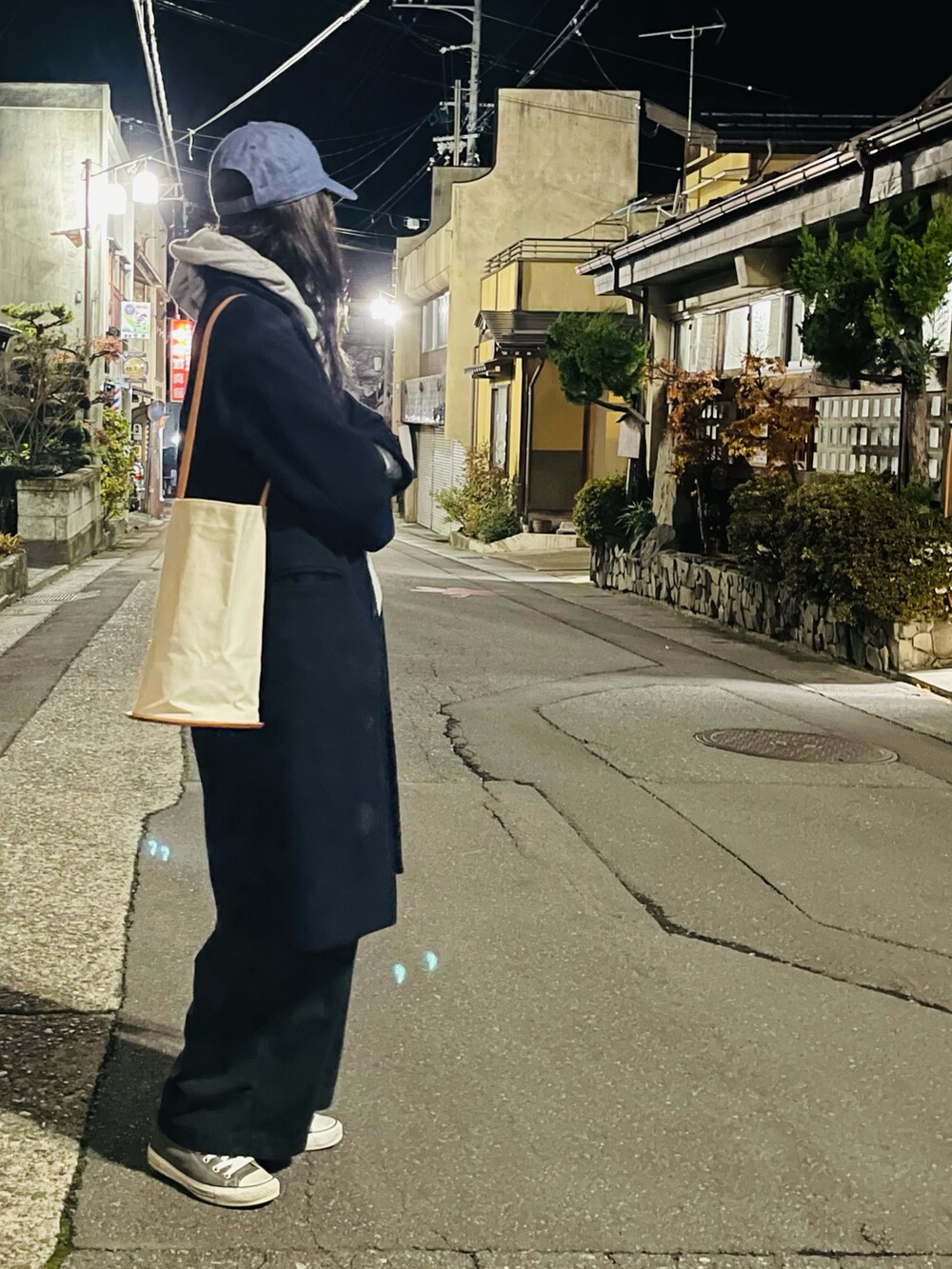 グレー系のパーカー、ブルー系のチェスターコート、ブラック系のチノパンツを着用したレディースの秋コーディネートの2枚目の写真