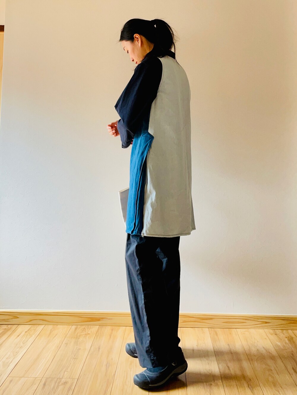 ブラック系のシャツ/ブラウス、ブルー系のワンピース、ブラック系のスラックスを着用したレディースの春コーディネートの2枚目の写真