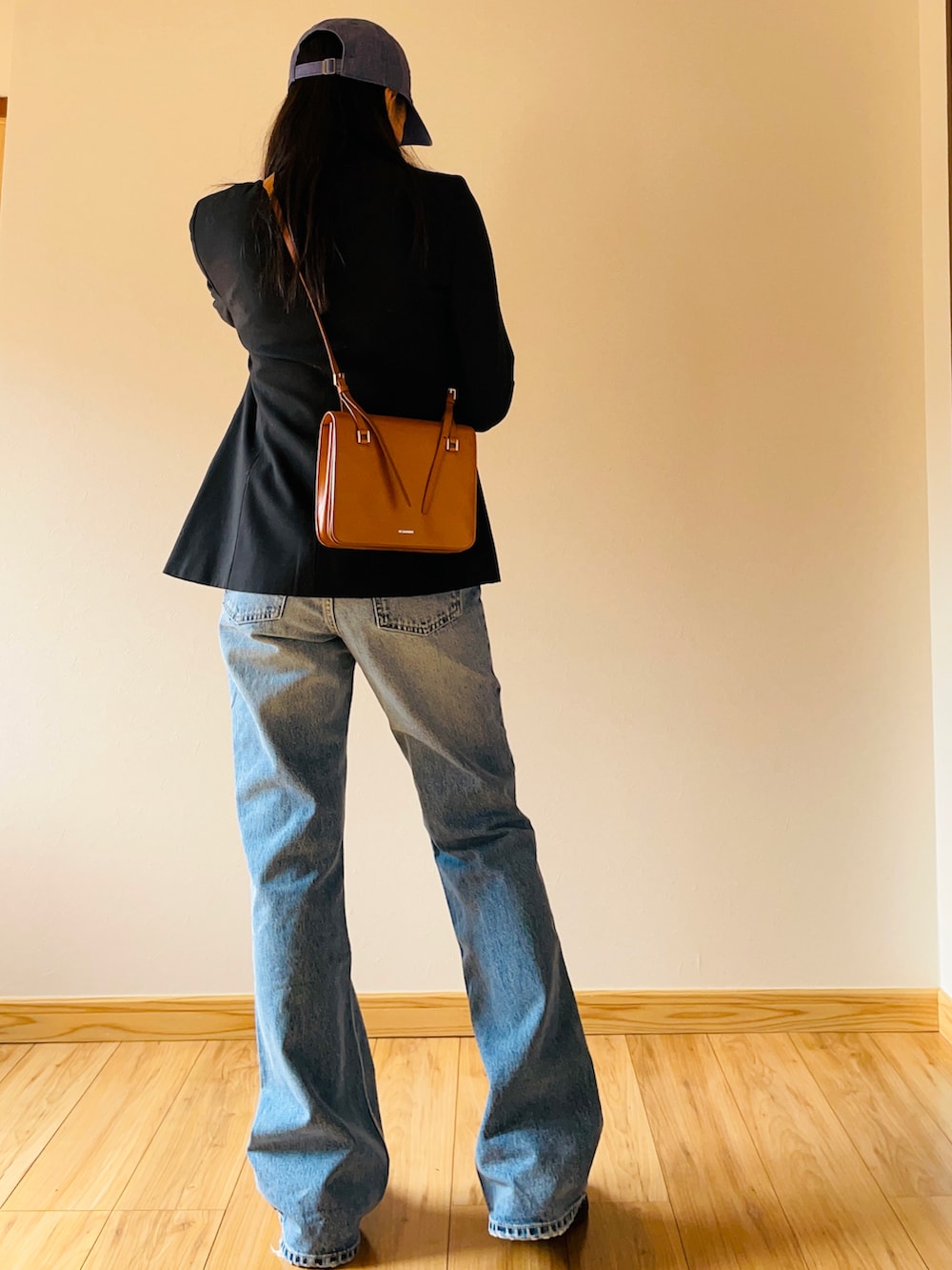 ブラック系のテーラードジャケット、ホワイト系のTシャツ/カットソー、ブラウン系のショルダーバッグを着用したレディースの春コーディネートの2枚目の写真