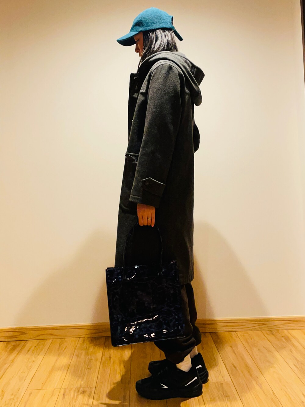 グレー系のニット/セーター、グレー系のダッフルコート、ブルー系のトートバッグを着用したレディースの冬コーディネートの2枚目の写真