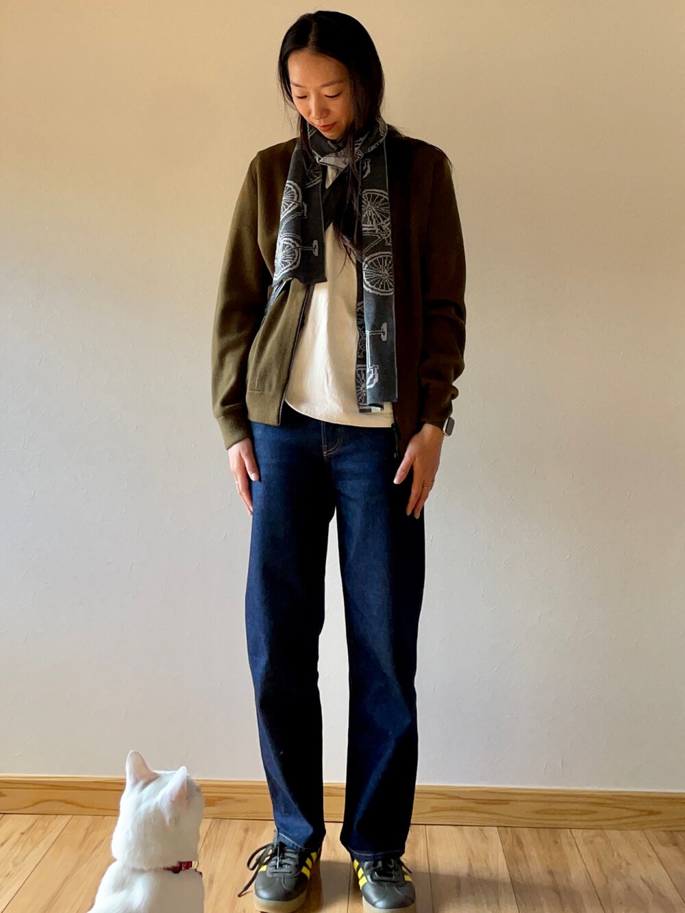 グリーン系のブルゾン、ブルー系のデニムパンツ、グリーン系のスニーカーを着用したレディースの秋コーディネートの5枚目の写真