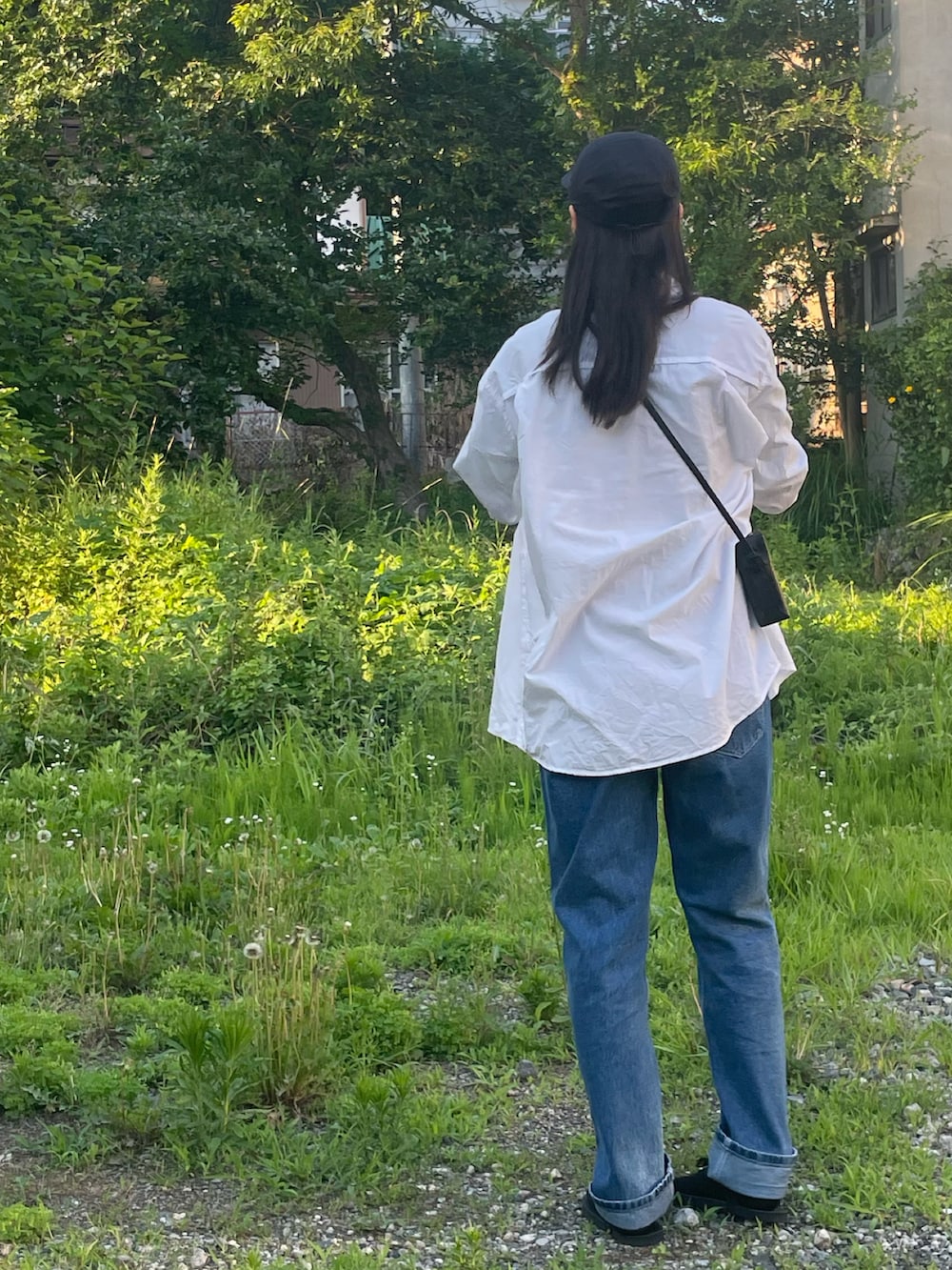 グレー系のTシャツ/カットソー、ブルー系のデニムパンツ、ブラック系のサンダルを着用したレディースの夏コーディネートの3枚目の写真