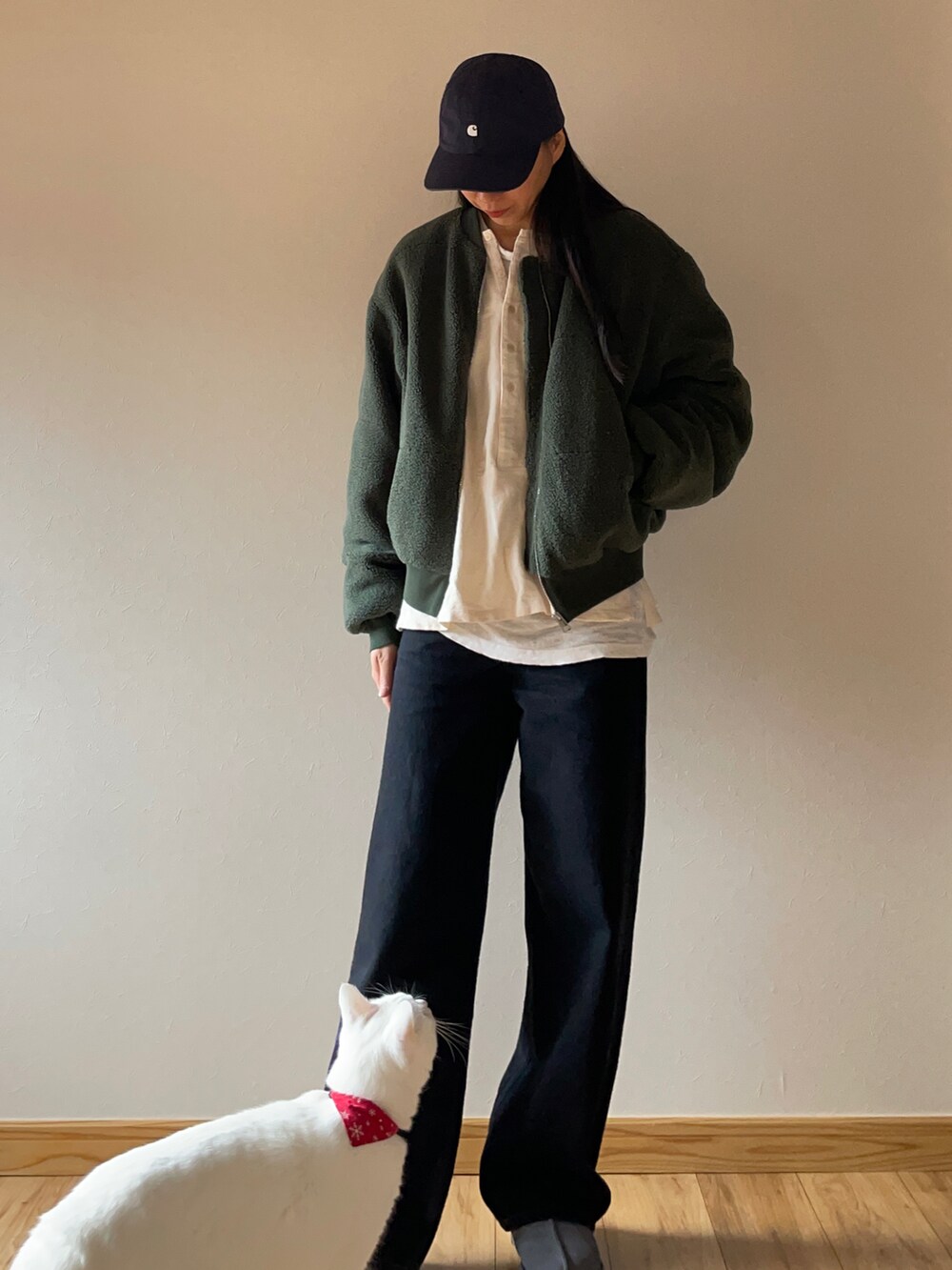 グリーン系のブルゾン、ブラック系のデニムパンツ、グレー系のスリッポンを着用したレディースの秋コーディネートの2枚目の写真