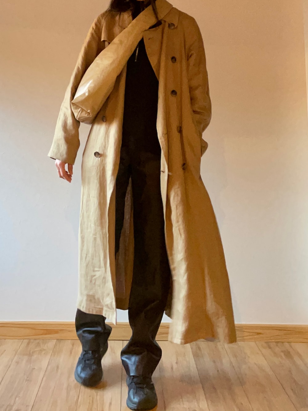 ブラック系のスニーカー、ブラック系のトップス、ベージュ系のトレンチコートを着用したレディースの秋コーディネートの2枚目の写真