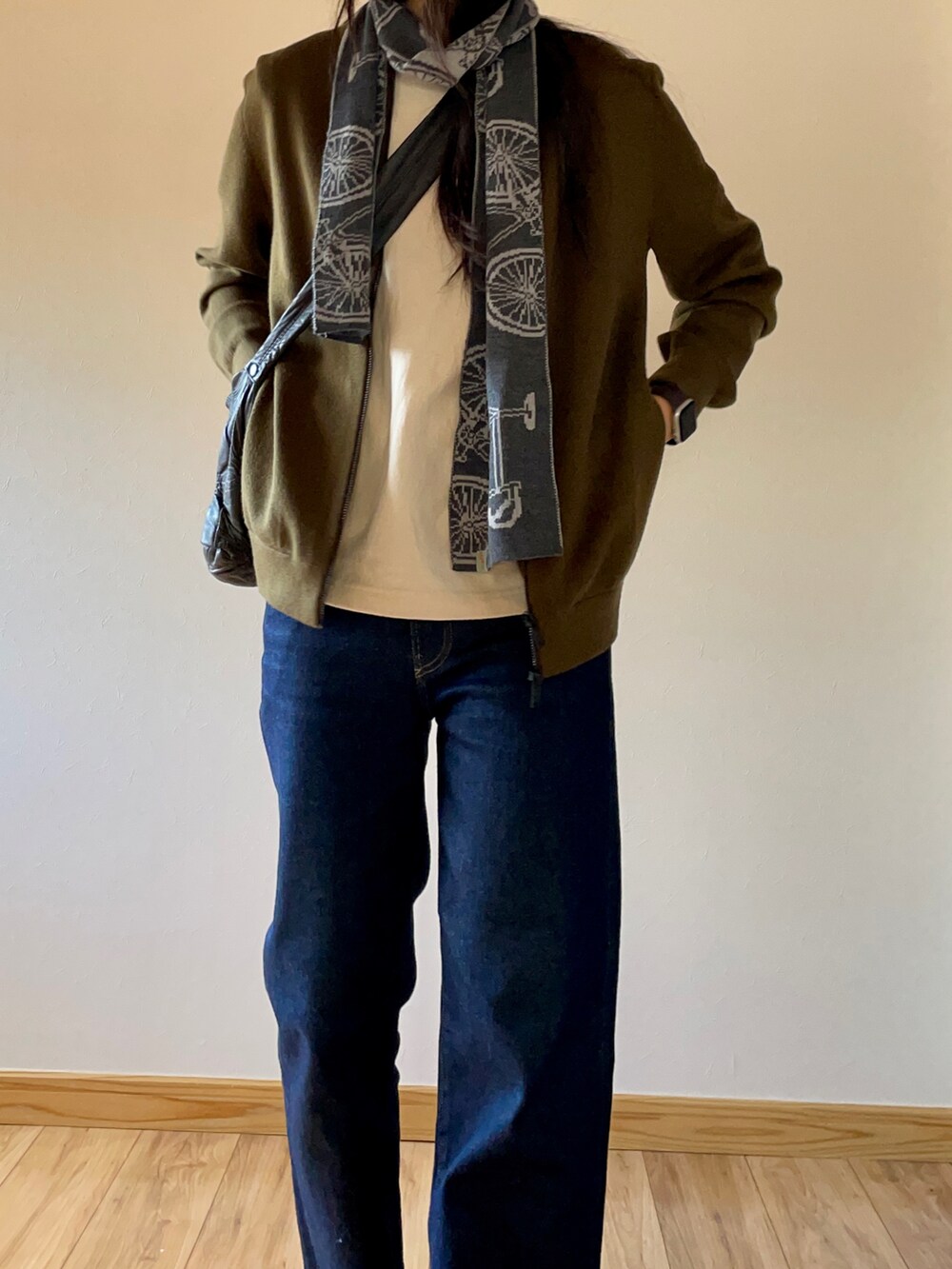 グリーン系のブルゾン、ブルー系のデニムパンツ、グリーン系のスニーカーを着用したレディースの秋コーディネートの4枚目の写真