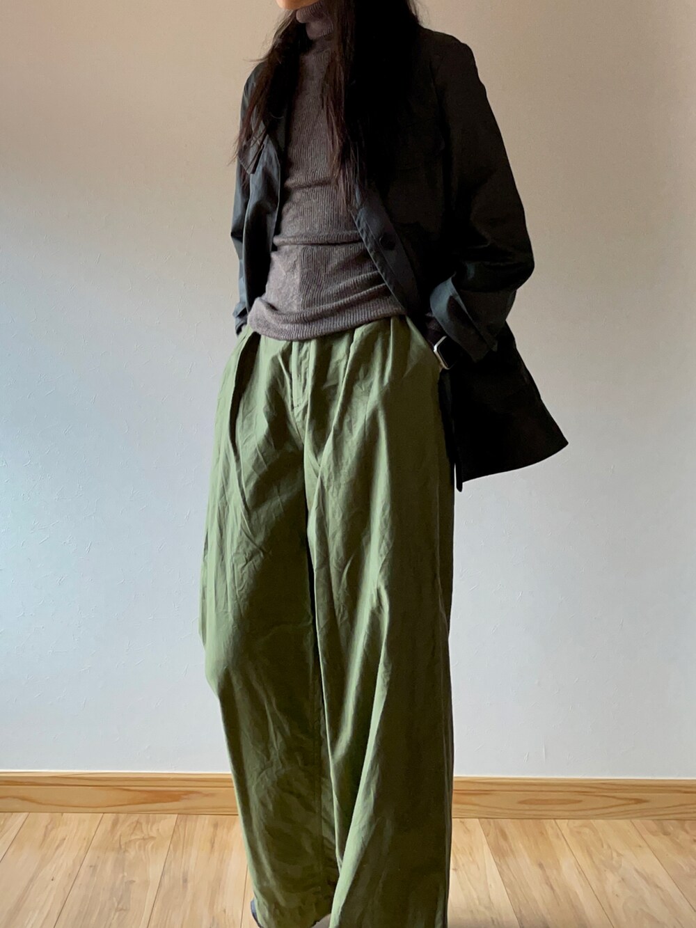 グリーン系のミリタリージャケット、ブラウン系のニット/セーター、グリーン系のスラックスを着用したレディースの秋コーディネートの4枚目の写真