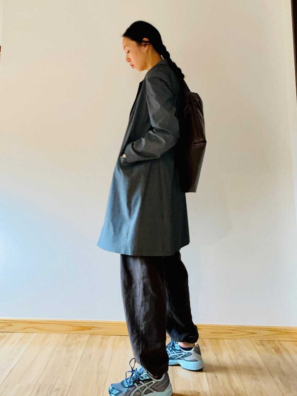 ブラウン系のショルダーバッグ、グレー系のジャケット/アウター、グレー系のスニーカーを着用したレディースの秋コーディネートの2枚目の写真