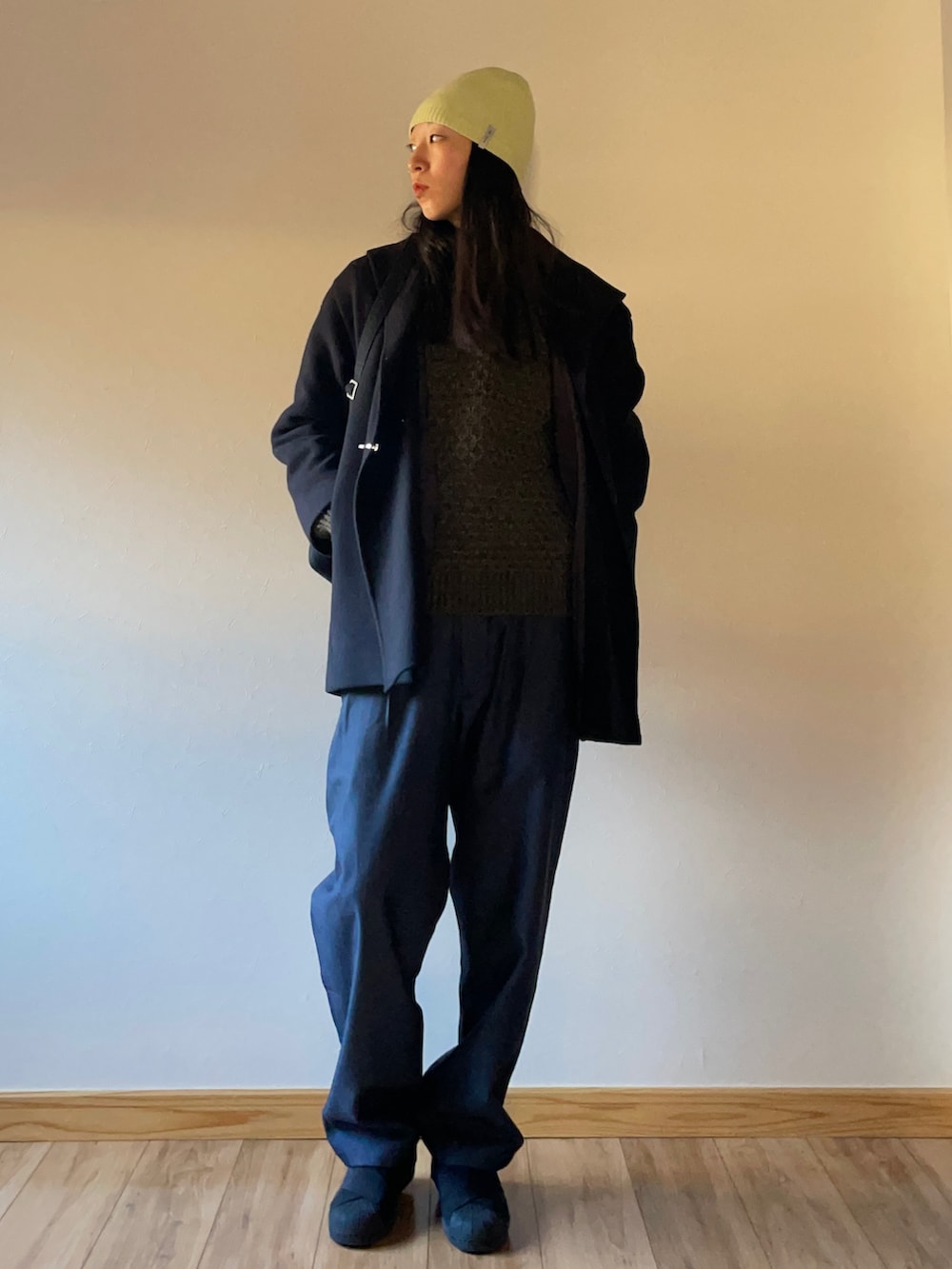 ブルー系のその他パンツ、ブラック系のスニーカー、グリーン系のニット/セーターを着用したレディースの冬コーディネートの2枚目の写真