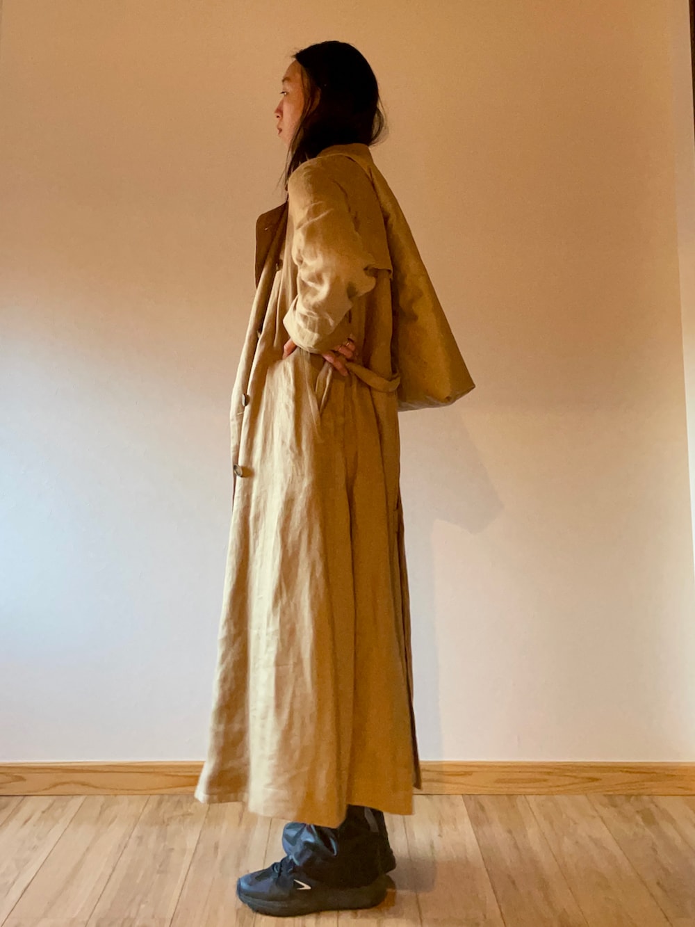 ブラック系のスニーカー、ブラック系のトップス、ベージュ系のトレンチコートを着用したレディースの秋コーディネートの3枚目の写真