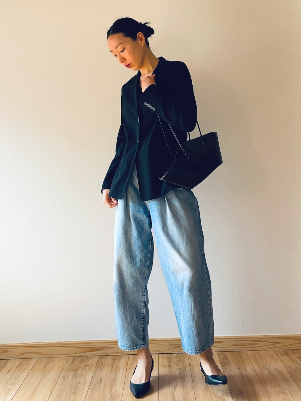 ブルー系のデニムパンツ、ブラック系のショルダーバッグ、ブラック系のキャミソールを着用したレディースの春コーディネートの2枚目の写真