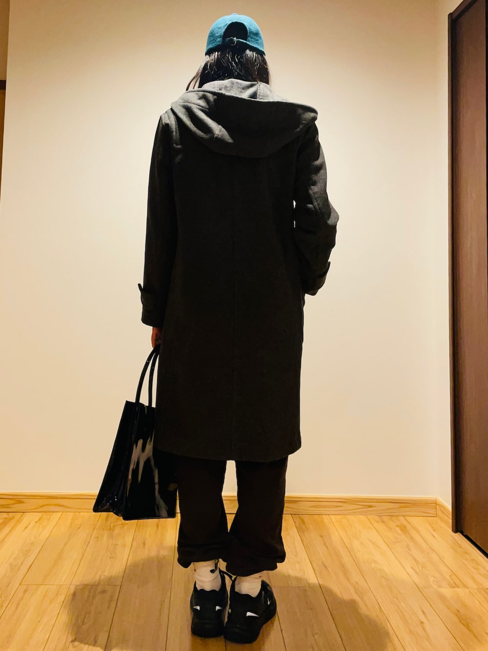 グレー系のニット/セーター、グレー系のダッフルコート、ブルー系のトートバッグを着用したレディースの冬コーディネートの3枚目の写真