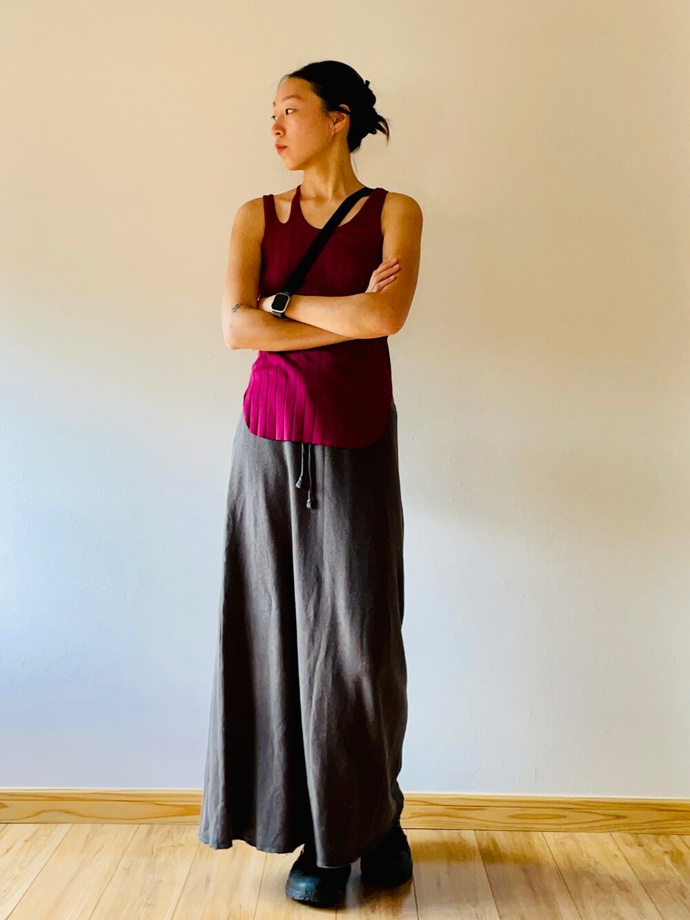 レッド系のタンクトップ、ブラック系のスカート、ブラック系のスニーカーを着用したレディースの夏コーディネートの2枚目の写真