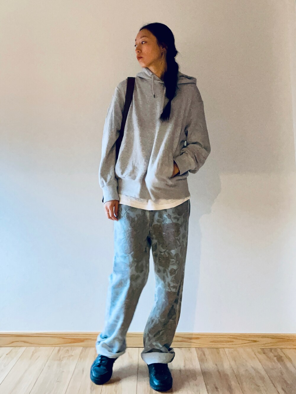 グレー系のパーカー、ブラック系のスニーカー、ブラウン系のショルダーバッグを着用したレディースの秋コーディネートの2枚目の写真