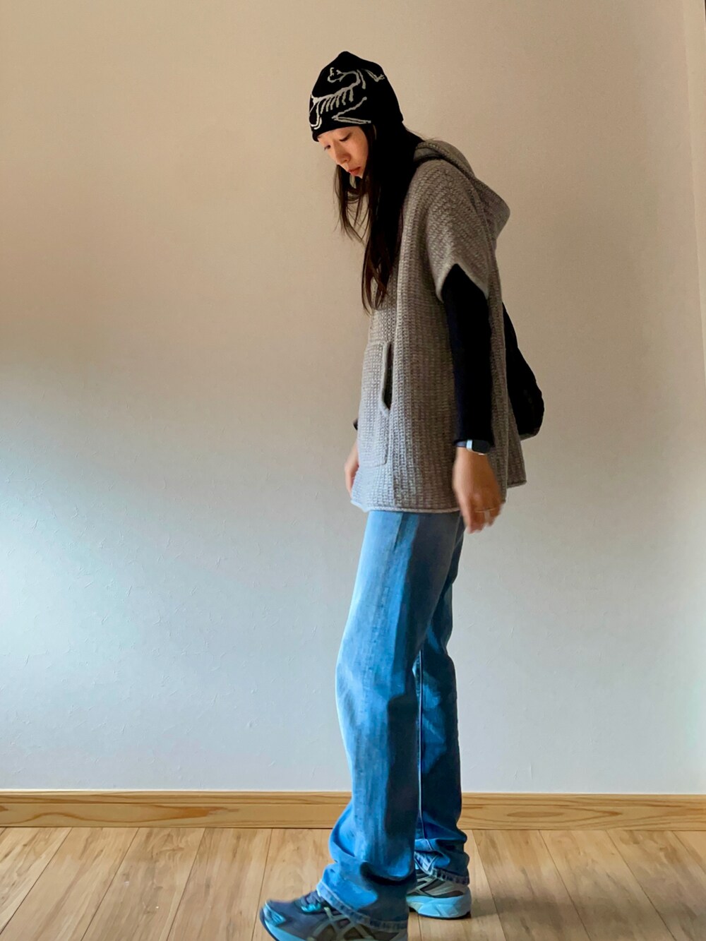 ブルー系のデニムパンツ、グレー系のスニーカー、ブラック系のショルダーバッグを着用したレディースの秋コーディネートの3枚目の写真