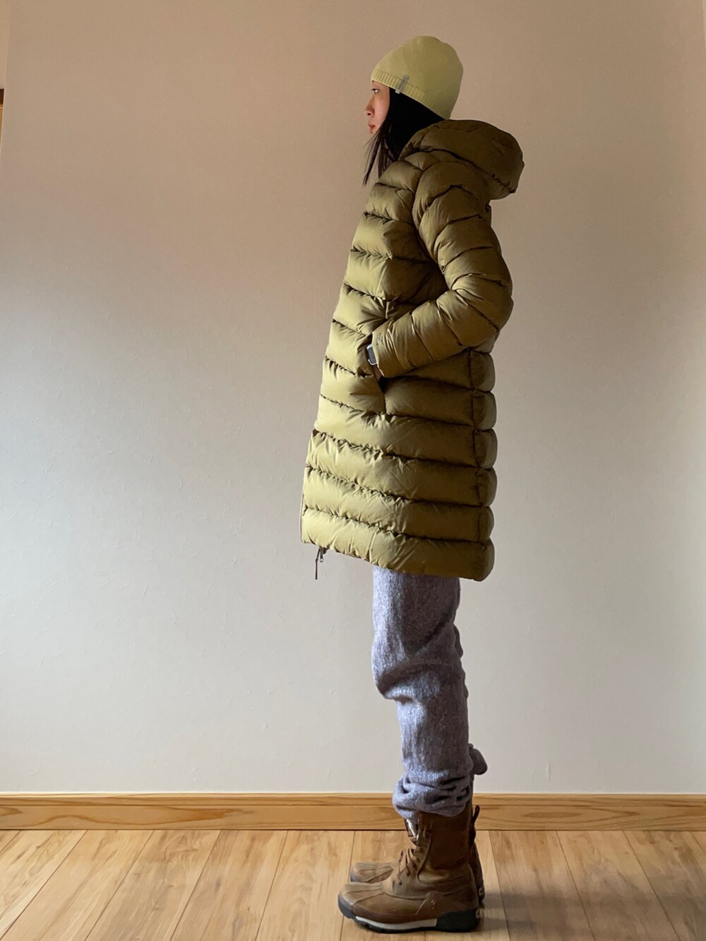 グリーン系のダウンジャケット/コート、ブルー系のニット/セーター、グレー系のその他パンツを着用したレディースの冬コーディネートの2枚目の写真