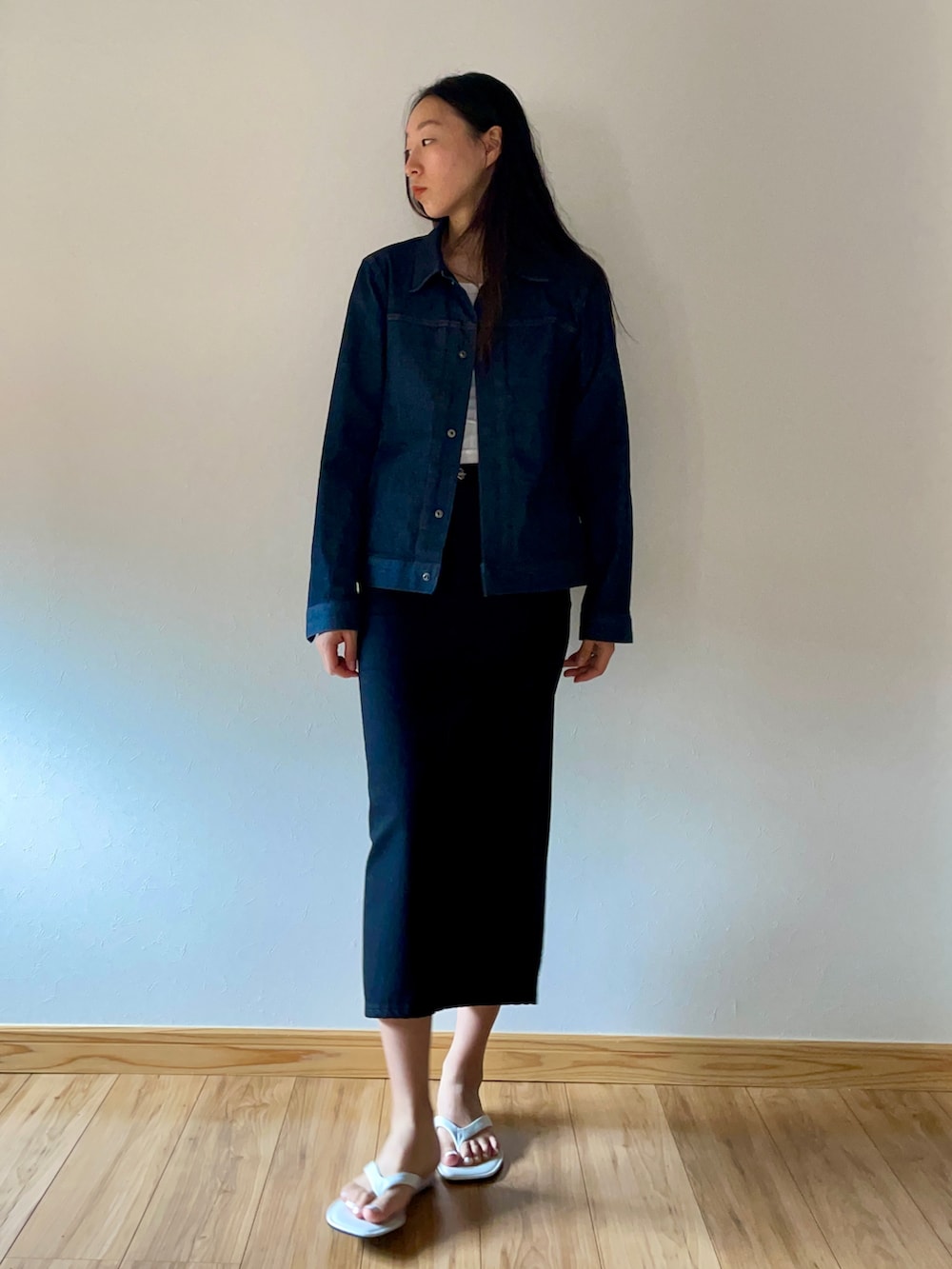 ブルー系のデニムジャケット、ブラック系のデニムスカート、ホワイト系のビーチサンダルを着用したレディースの夏コーディネートの2枚目の写真