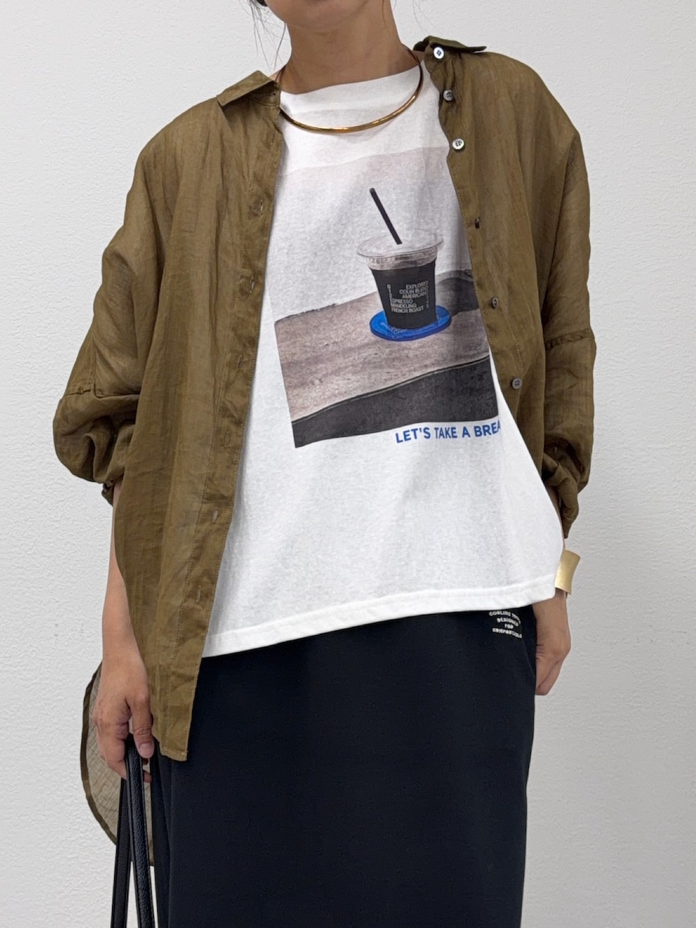 ブラック系のスカート、ブラウン系のシャツ/ブラウス、ホワイト系のTシャツ/カットソーを着用したレディースの夏コーディネートの3枚目の写真