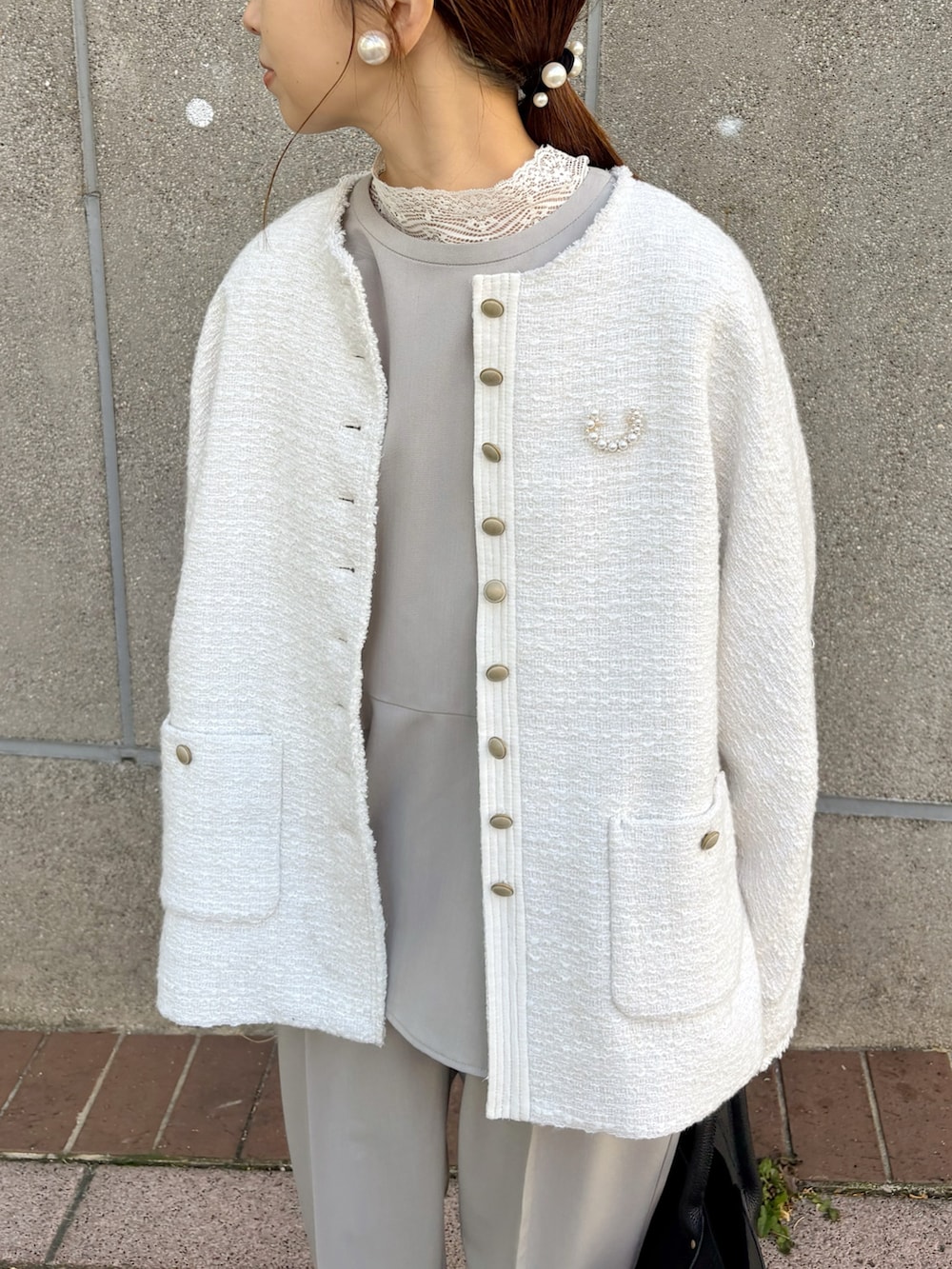 ブラック系のトートバッグ、ホワイト系のノーカラージャケット、ホワイト系のTシャツ/カットソーを着用したレディースの冬コーディネートの2枚目の写真