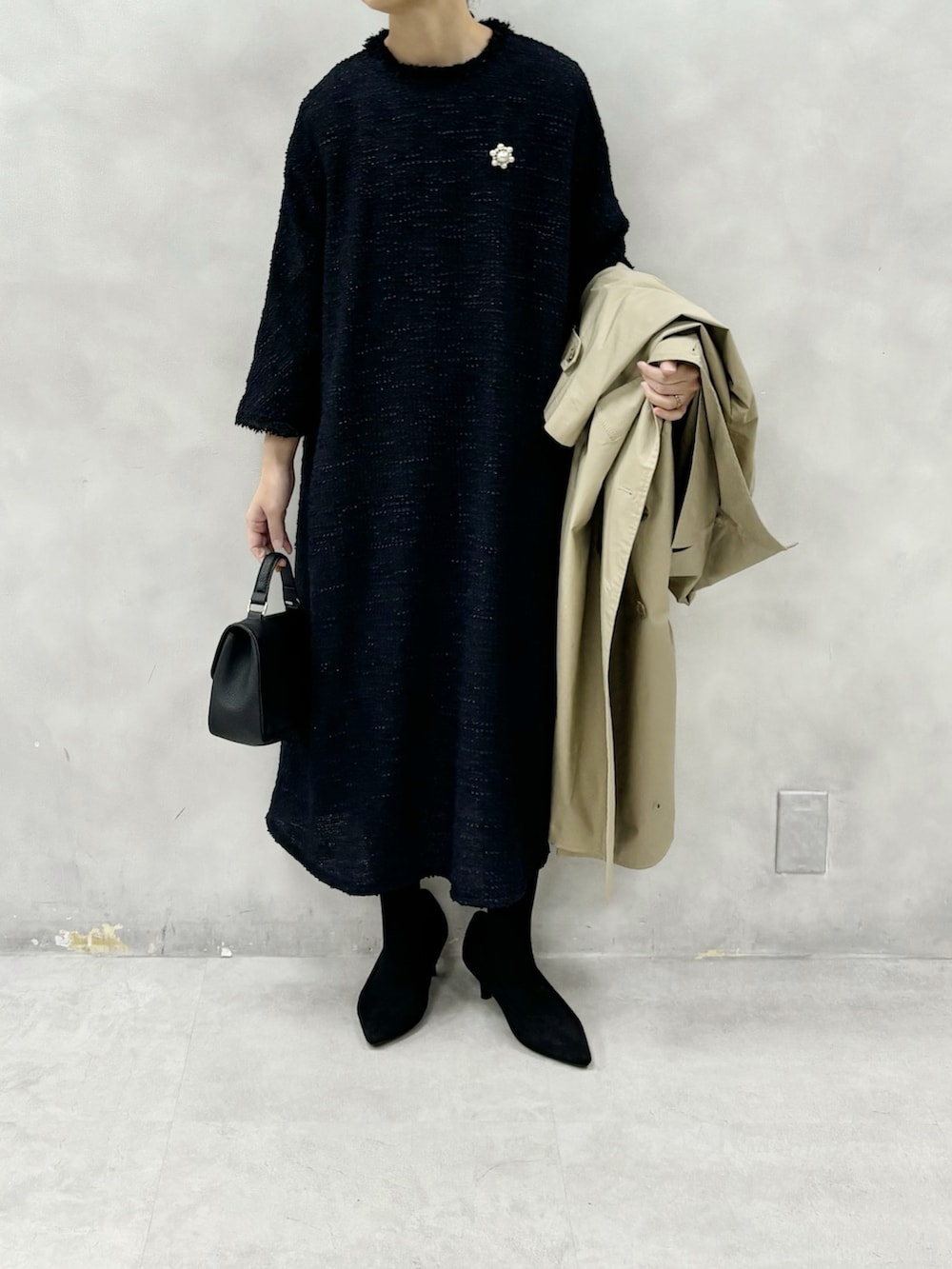 ベージュ系のトレンチコート、ブルー系のワンピース、その他のブローチ/コサージュを着用したレディースの冬コーディネートの4枚目の写真