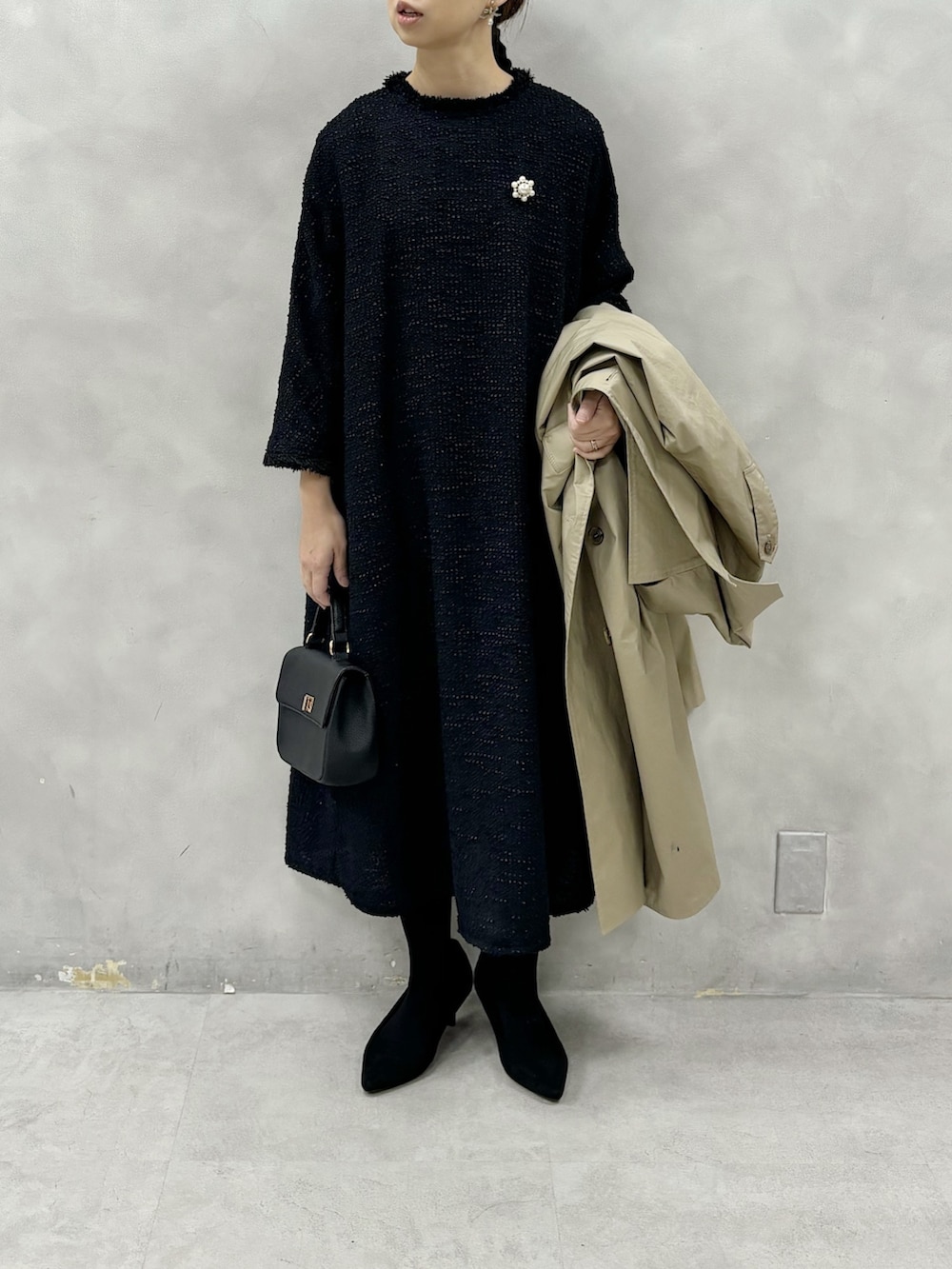 ベージュ系のトレンチコート、ブルー系のワンピース、その他のブローチ/コサージュを着用したレディースの冬コーディネートの3枚目の写真