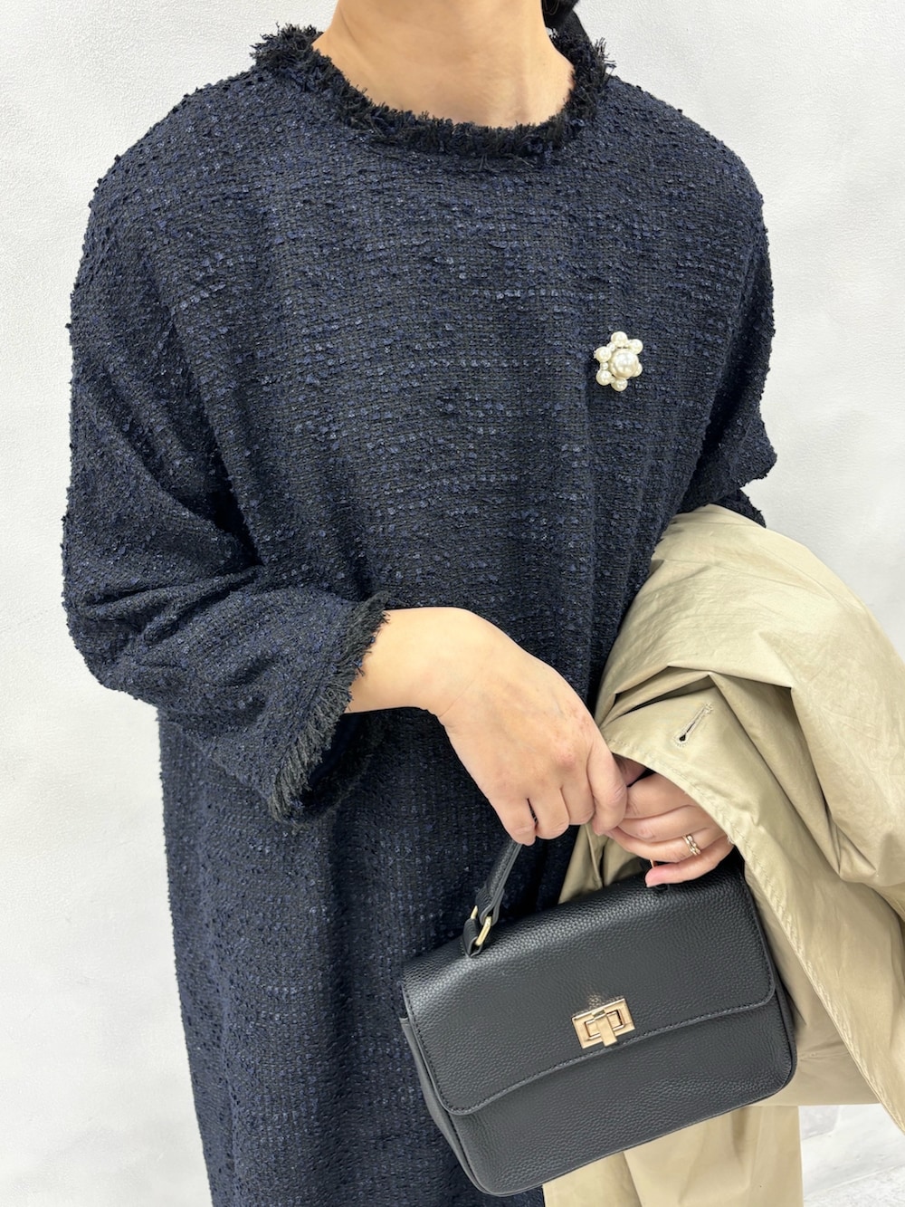 ベージュ系のトレンチコート、ブルー系のワンピース、その他のブローチ/コサージュを着用したレディースの冬コーディネートの5枚目の写真