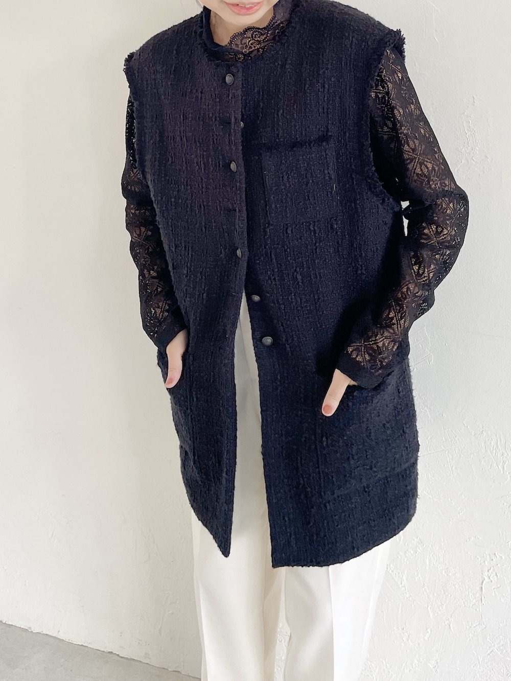 ブラック系のTシャツ/カットソー、ブラック系のベスト、ホワイト系のパンツを着用したレディースの春コーディネートの3枚目の写真