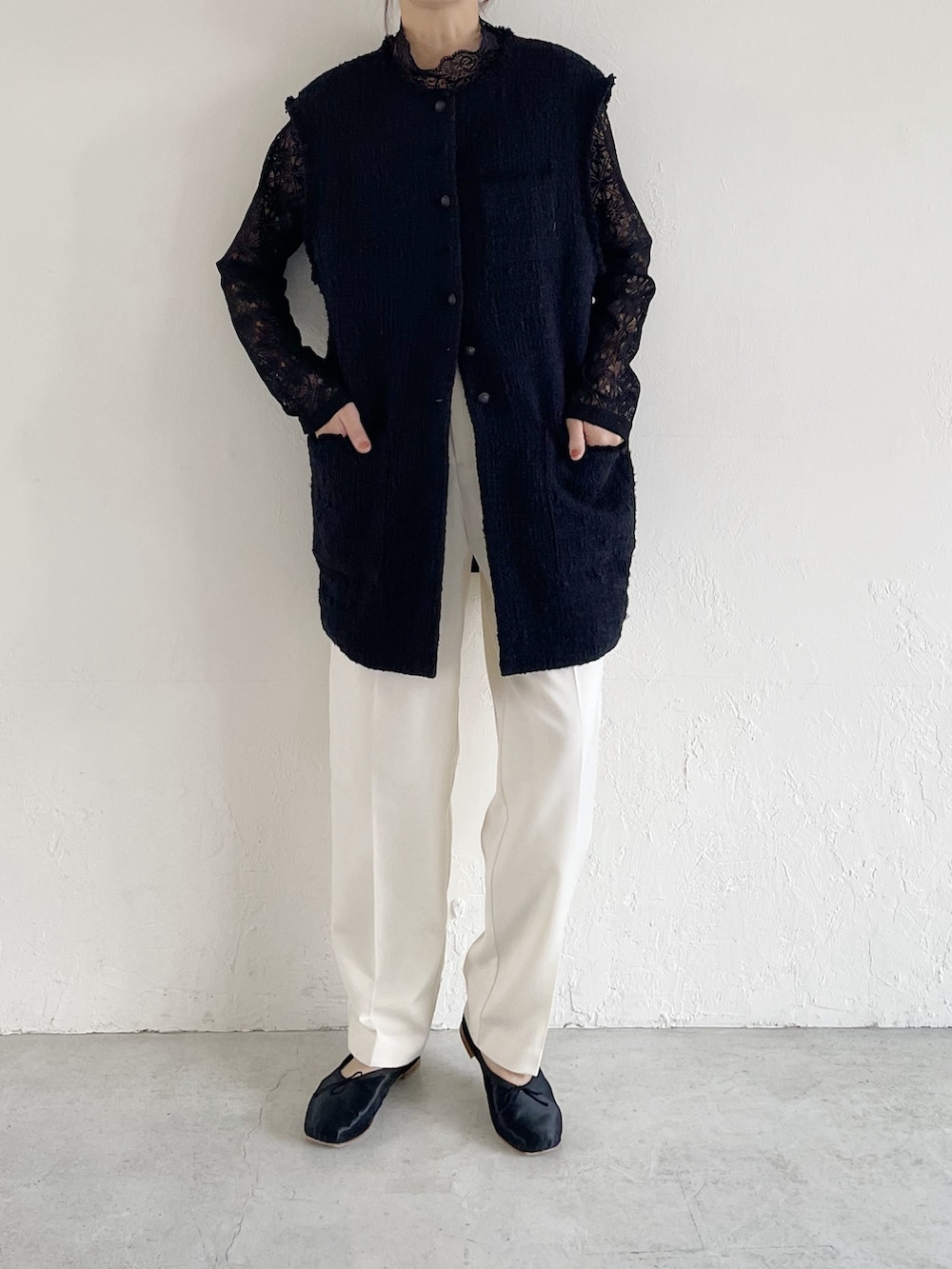 ブラック系のTシャツ/カットソー、ブラック系のベスト、ホワイト系のパンツを着用したレディースの春コーディネートの2枚目の写真