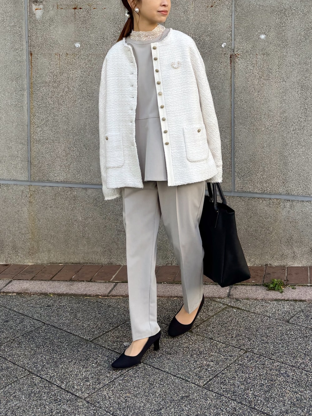 ブラック系のトートバッグ、ホワイト系のノーカラージャケット、ホワイト系のTシャツ/カットソーを着用したレディースの冬コーディネートの3枚目の写真