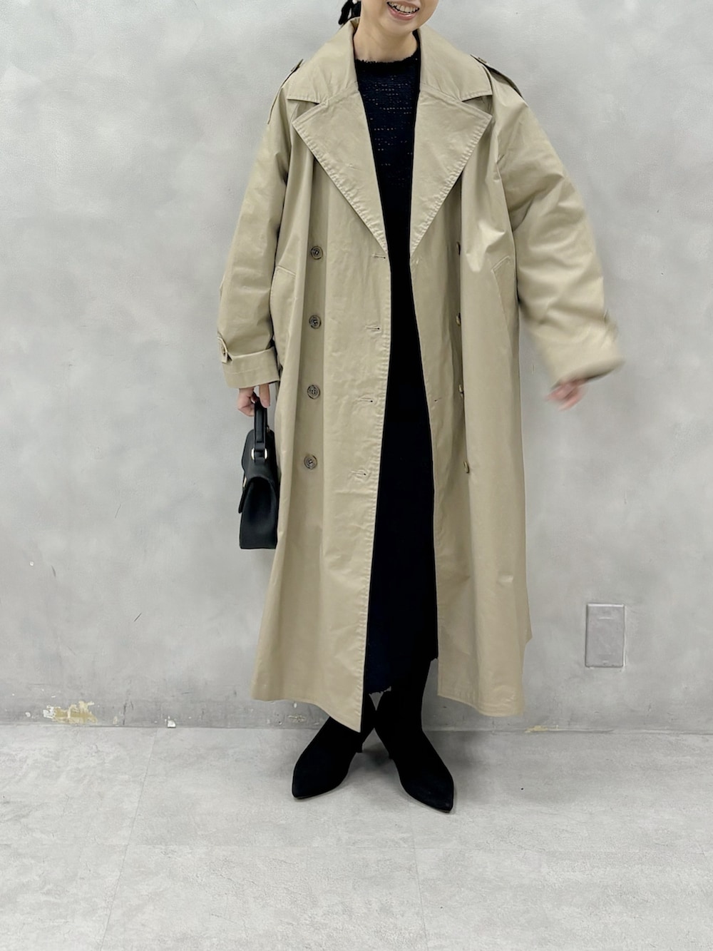 ベージュ系のトレンチコート、ブルー系のワンピース、その他のブローチ/コサージュを着用したレディースの冬コーディネートの2枚目の写真