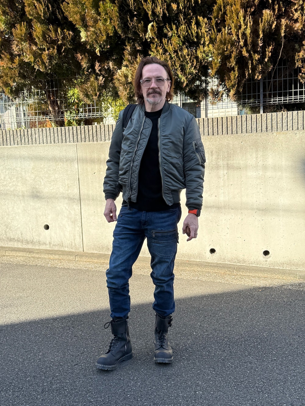 ブルー系のデニムパンツ、グリーン系のMA-1、ブラック系のニット/セーターを着用したメンズの冬コーディネートの2枚目の写真