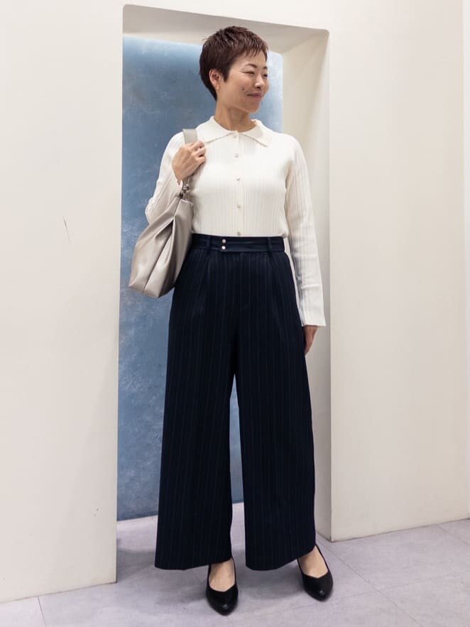 ベージュ系のニット/セーター、ベージュ系のスカート、ブラック系のショルダーバッグを着用したレディースの春コーディネートの6枚目の写真