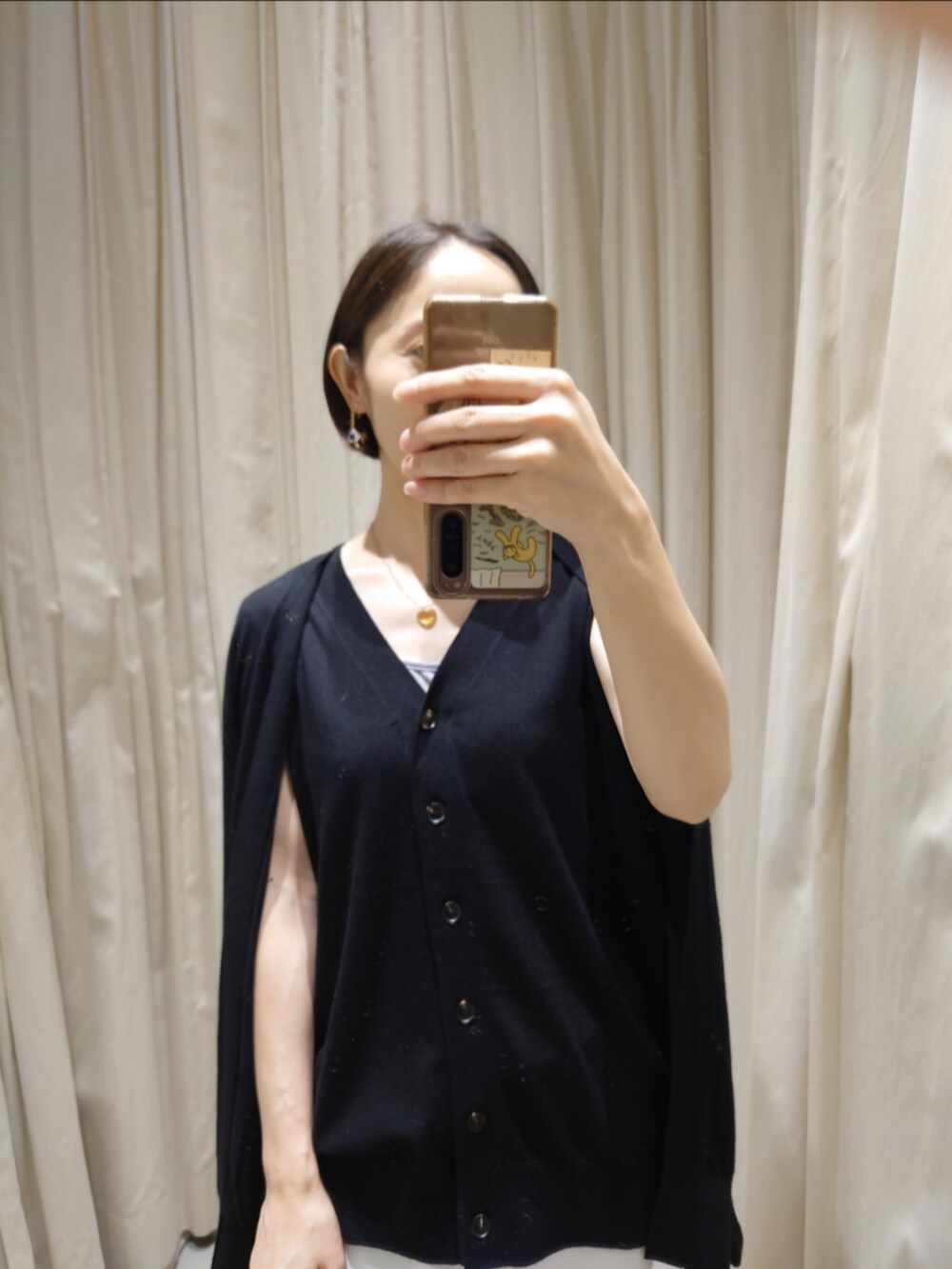 ブラック系のカーディガン/ボレロ、ホワイト系のデニムパンツ、ブラック系のトートバッグを着用したレディースの秋コーディネートの4枚目の写真