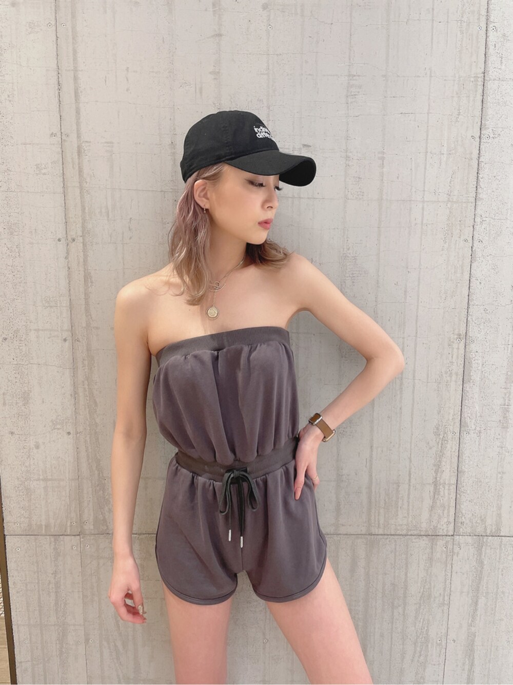 グレー系のつなぎ/オールインワン、ブラック系のキャップを着用したレディースの春コーディネートの2枚目の写真