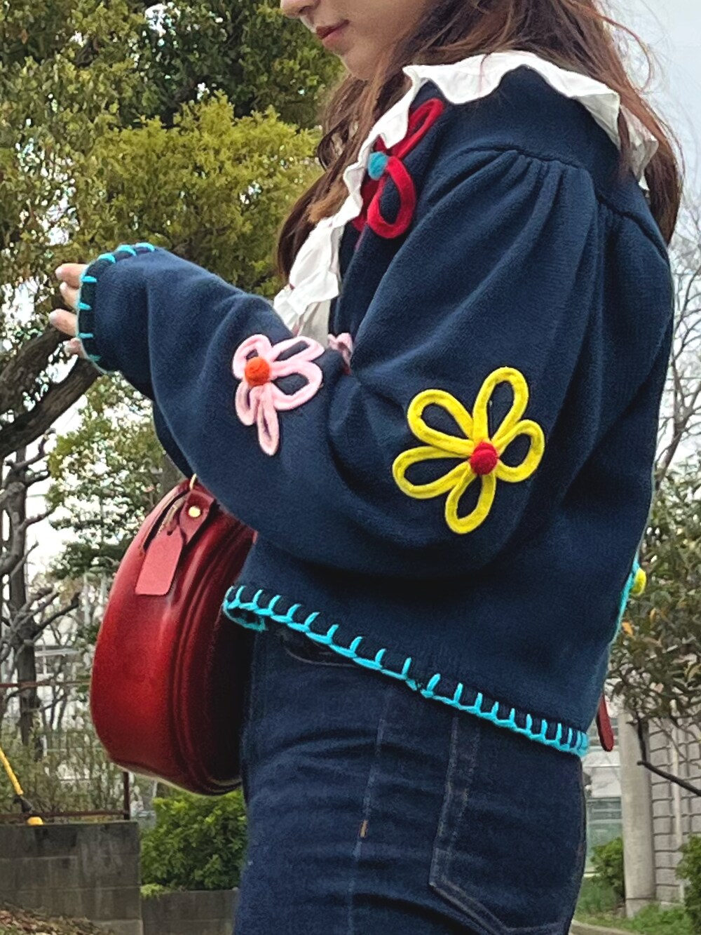 ブルー系のカーディガン/ボレロ、ホワイト系のシャツ/ブラウス、ブルー系のデニムパンツを着用したレディースの春コーディネートの2枚目の写真