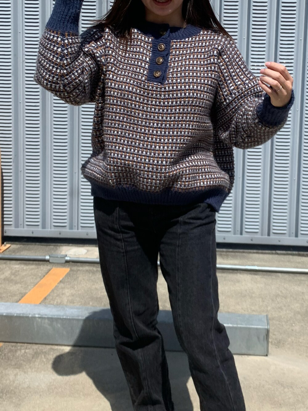 ブルー系のニット/セーター、ブラック系のデニムパンツ、グレー系のスニーカーを着用したレディースの春コーディネートの2枚目の写真