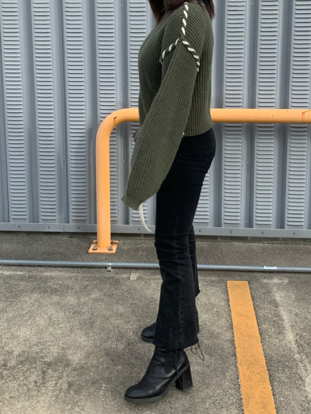 ブラック系のニット/セーター、ブラック系のデニムパンツ、ブラウン系の財布/小物を着用したレディースの冬コーディネートの2枚目の写真