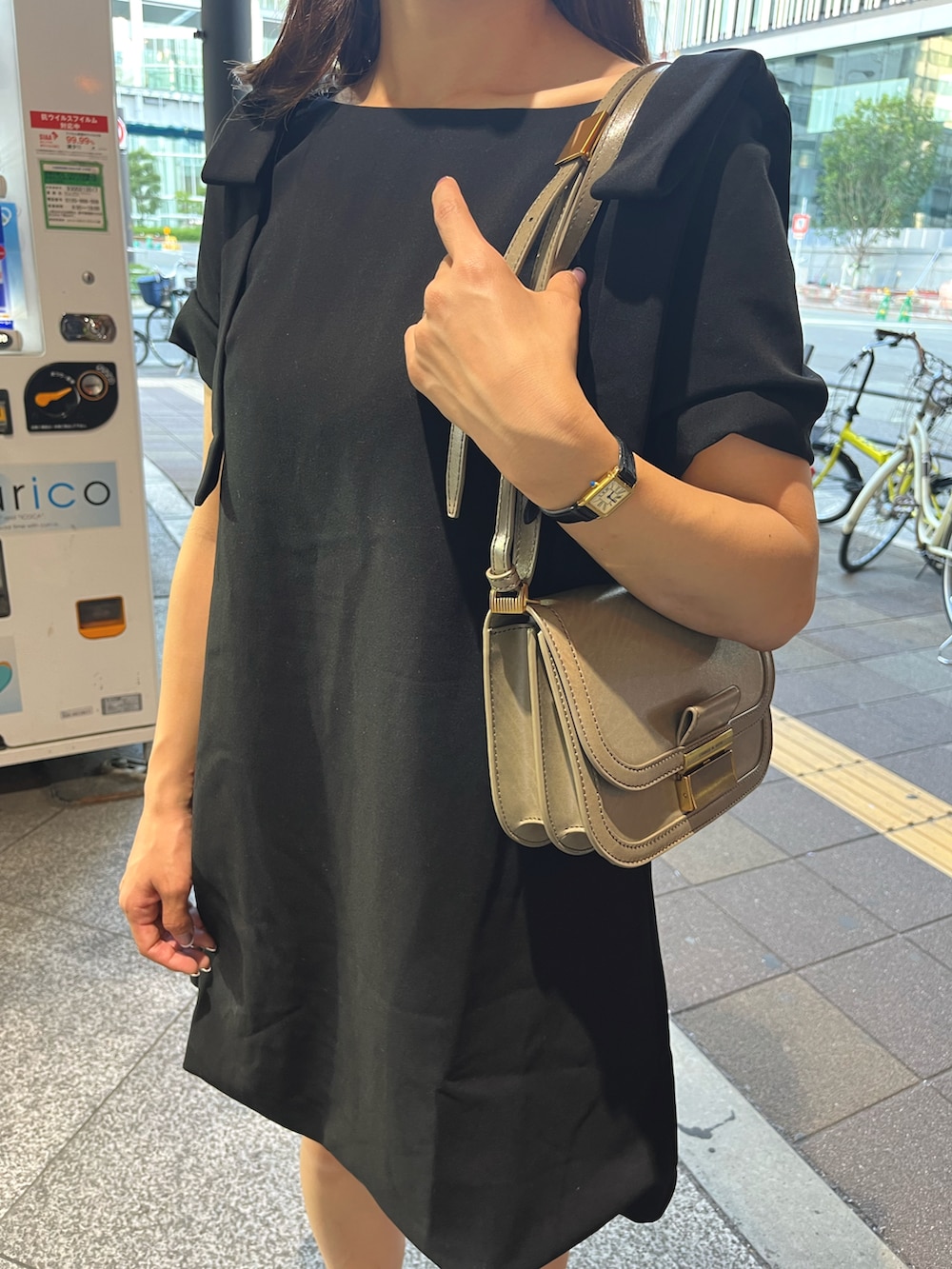 ブラック系のワンピース、ベージュ系のショルダーバッグ、ブラック系のサンダルを着用したレディースの夏コーディネートの2枚目の写真