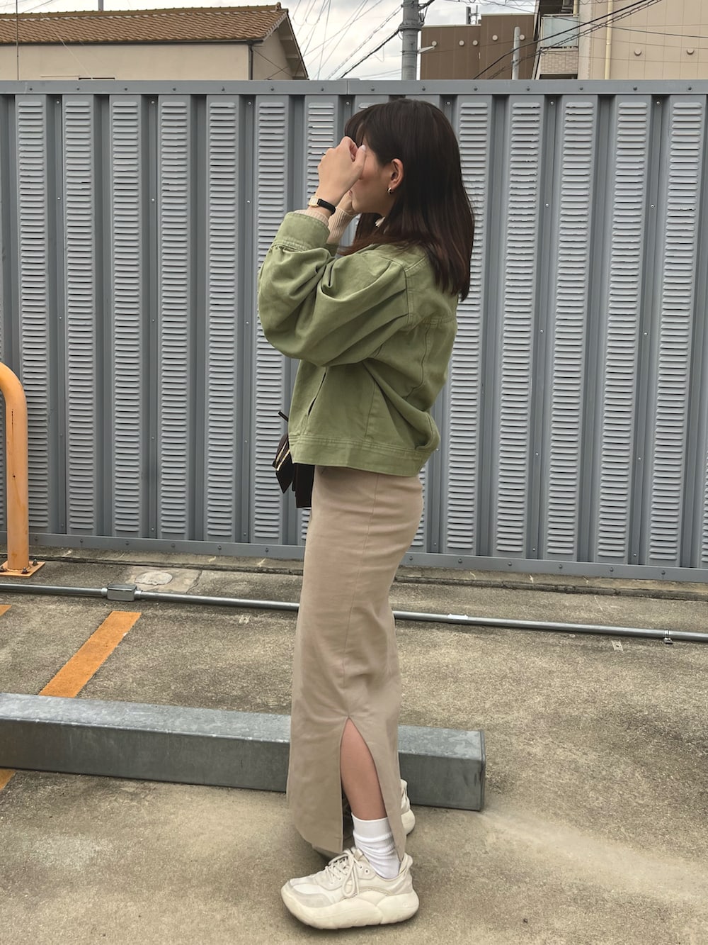 グリーン系のデニムジャケット、ホワイト系のTシャツ/カットソー、ベージュ系のシャツ/ブラウスを着用したレディースの春コーディネートの2枚目の写真