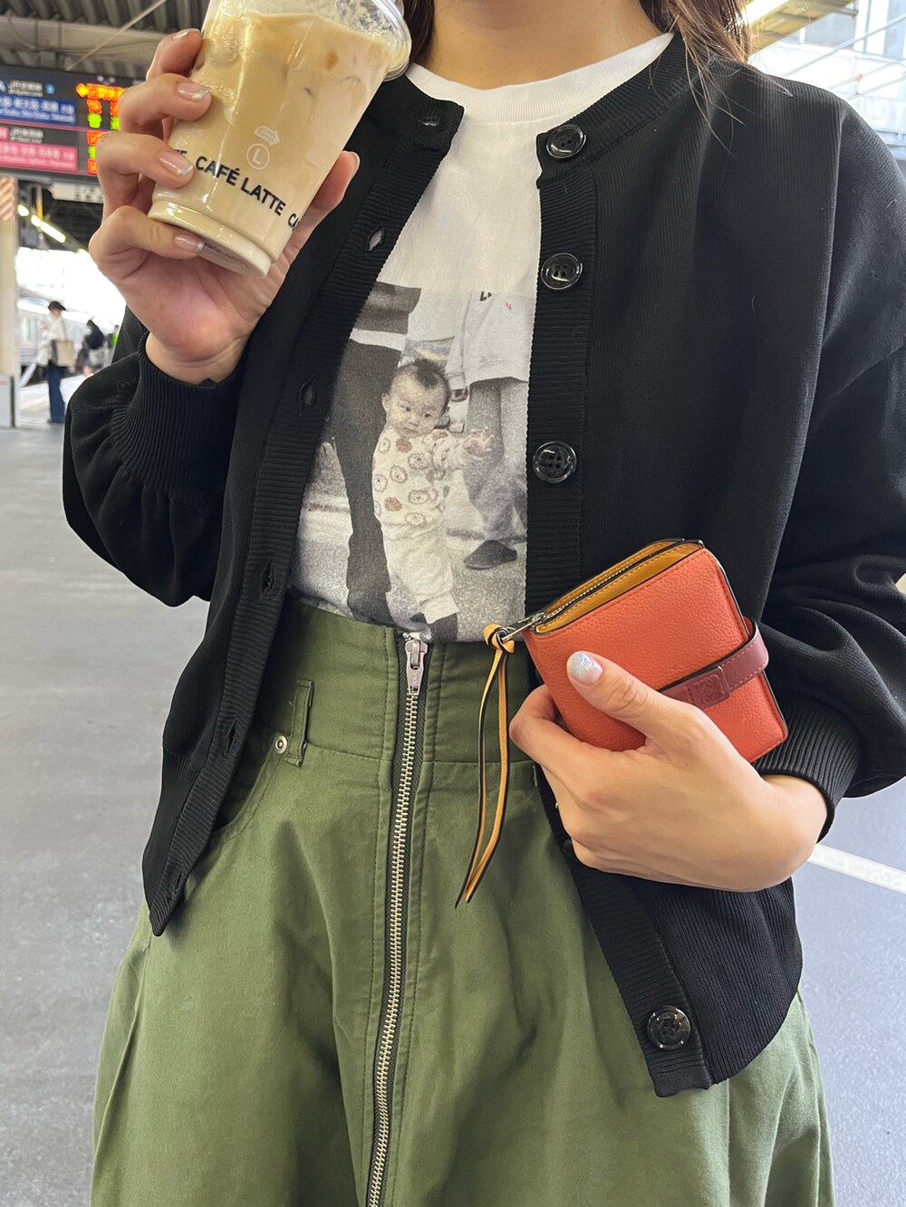 ブラック系のパンプス、グリーン系のスカート、ブラック系のカーディガン/ボレロを着用したレディースの春コーディネートの2枚目の写真