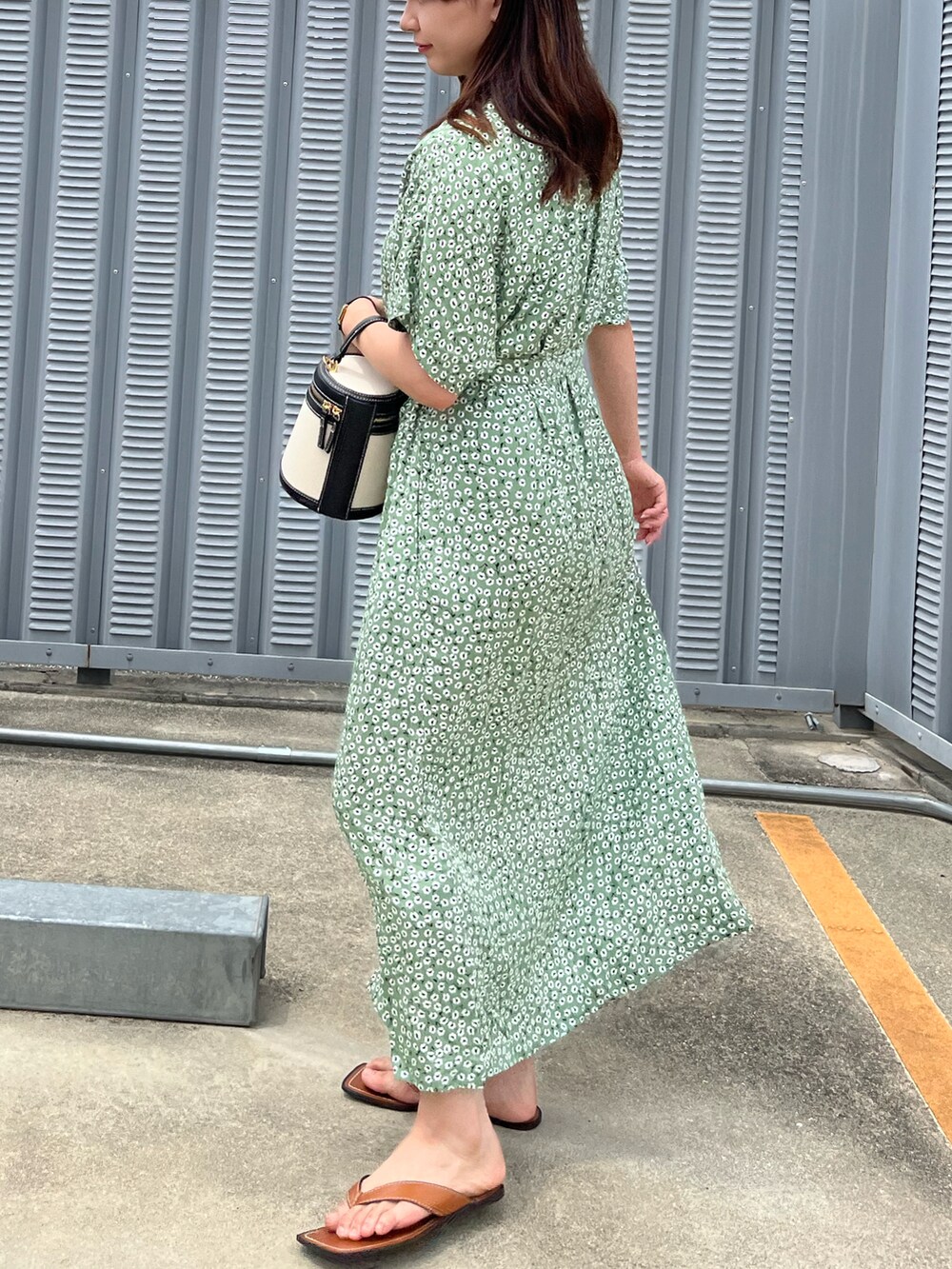 グリーン系のワンピース/ドレス、ホワイト系のハンドバッグ、ブラウン系のサンダルを着用したレディースの夏コーディネートの2枚目の写真