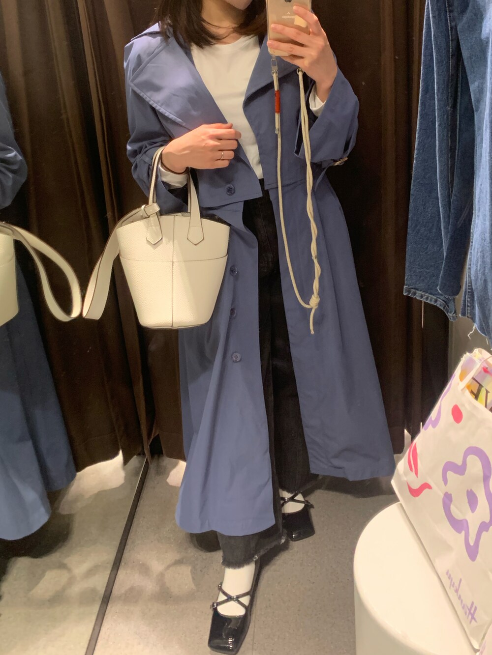 ブルー系のトレンチコート、ホワイト系のTシャツ/カットソー、ホワイト系のハンドバッグを着用したレディースの春コーディネートの2枚目の写真