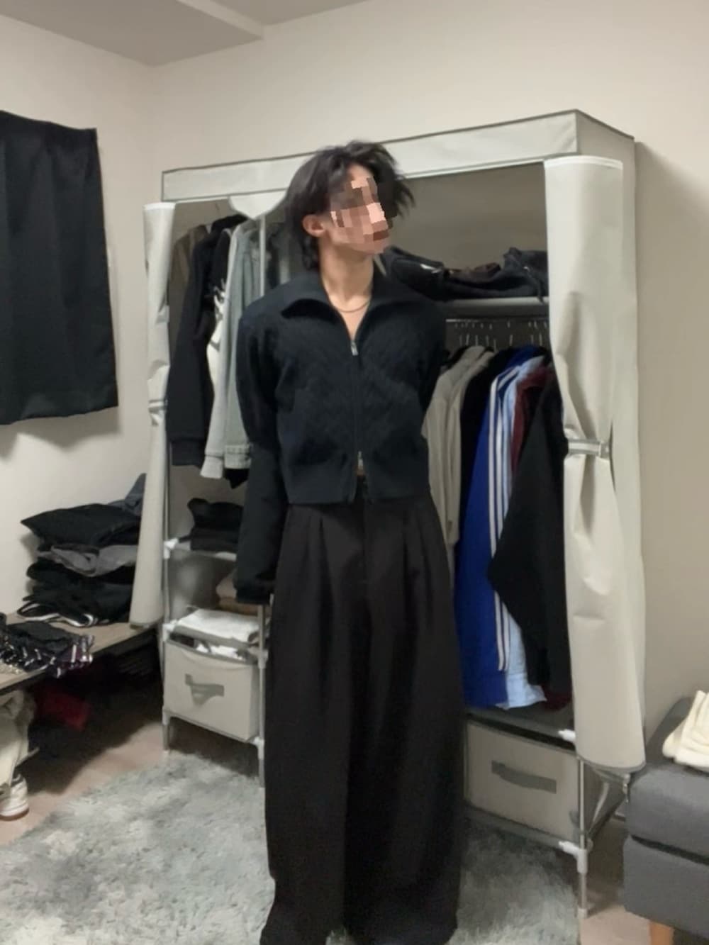 ブラック系のスラックス、ブルー系のニット/セーターを着用したメンズの春コーディネートの3枚目の写真