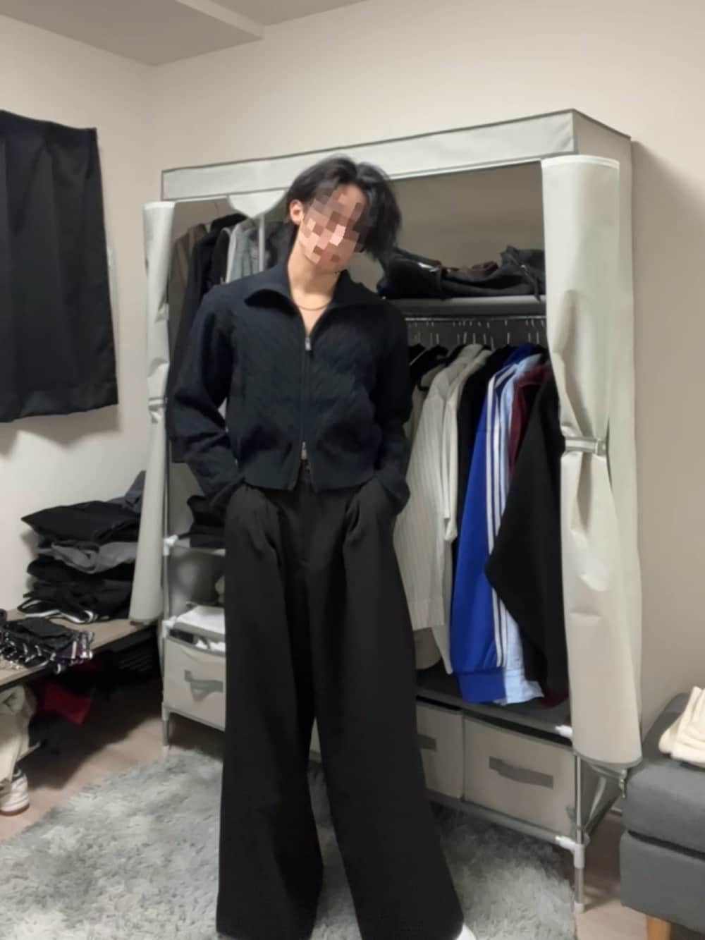 ブラック系のスラックス、ブルー系のニット/セーターを着用したメンズの春コーディネートの2枚目の写真