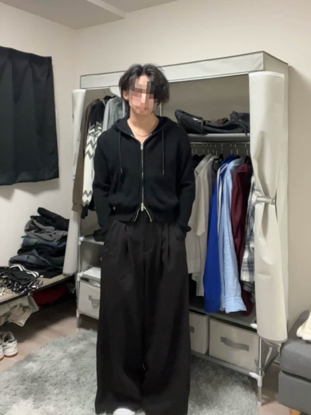 ブラック系のスラックス、ブラック系のパーカーを着用したメンズの春コーディネートの2枚目の写真