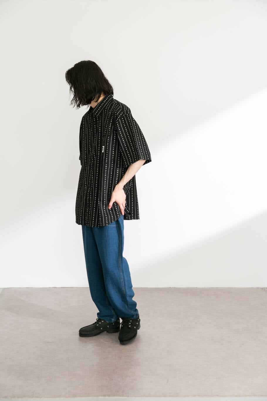 ブラック系のシャツ/ブラウス、ブルー系のデニムパンツを着用したメンズの春コーディネートの2枚目の写真