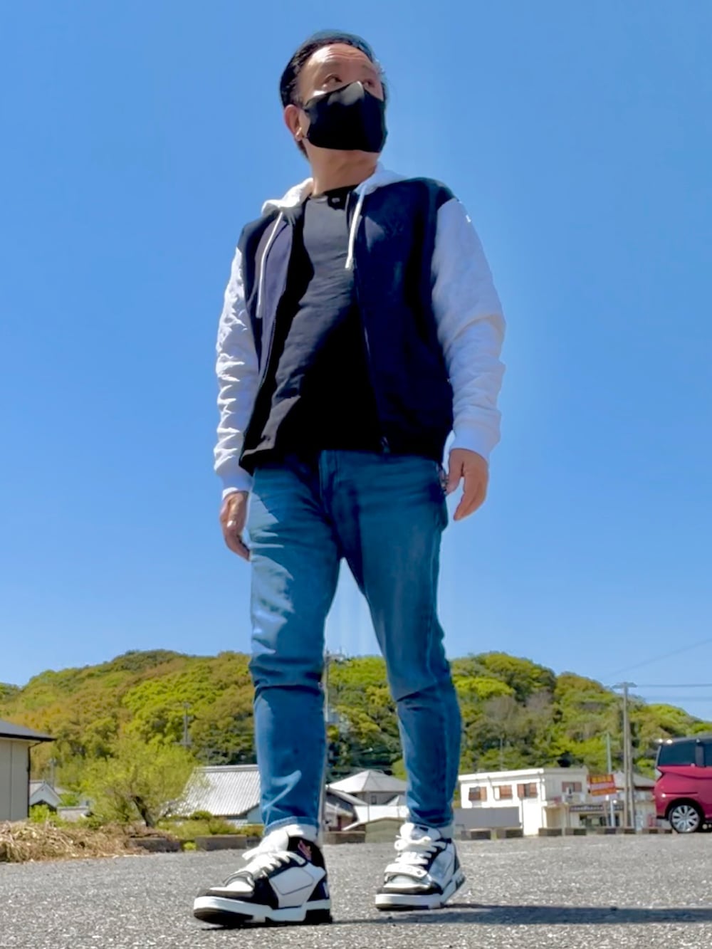 グレー系のパーカー、ブラック系のTシャツ/カットソー、ホワイト系のスニーカーを着用したメンズの春コーディネートの2枚目の写真